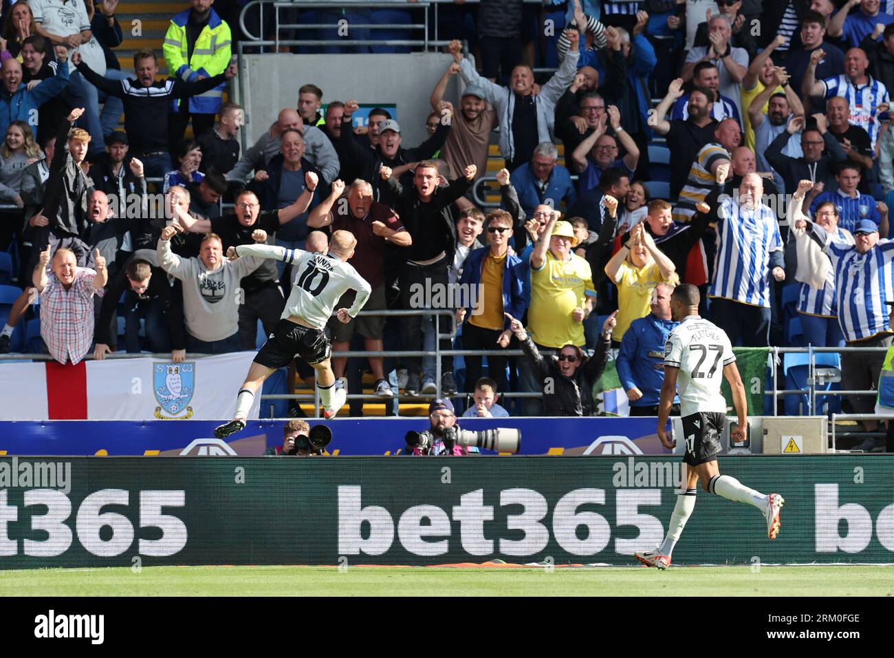 Cardiff, Regno Unito. 26 agosto 2023. Barry Bannan di Sheffield Wednesday festeggia verso i tifosi dello Sheffield Wed dopo aver segnato il primo gol della sua squadra. Partita di campionato EFL Skybet, Cardiff City contro Sheffield mercoledì al Cardiff City Stadium di Cardiff, Galles, sabato 26 agosto 2023. Questa immagine può essere utilizzata solo per scopi editoriali. Solo per uso editoriale, foto di Andrew Orchard/Andrew Orchard fotografia sportiva/Alamy Live news credito: Andrew Orchard fotografia sportiva/Alamy Live News Foto Stock