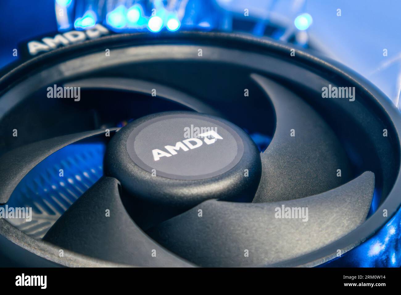 Kiev, Ucraina - 5 gennaio 2022: Primo piano del radiatore di raffreddamento AMD per unità CPU PC desktop in luce blu. Ventola di raffreddamento nera, dettagli hardware PC. Componen Foto Stock