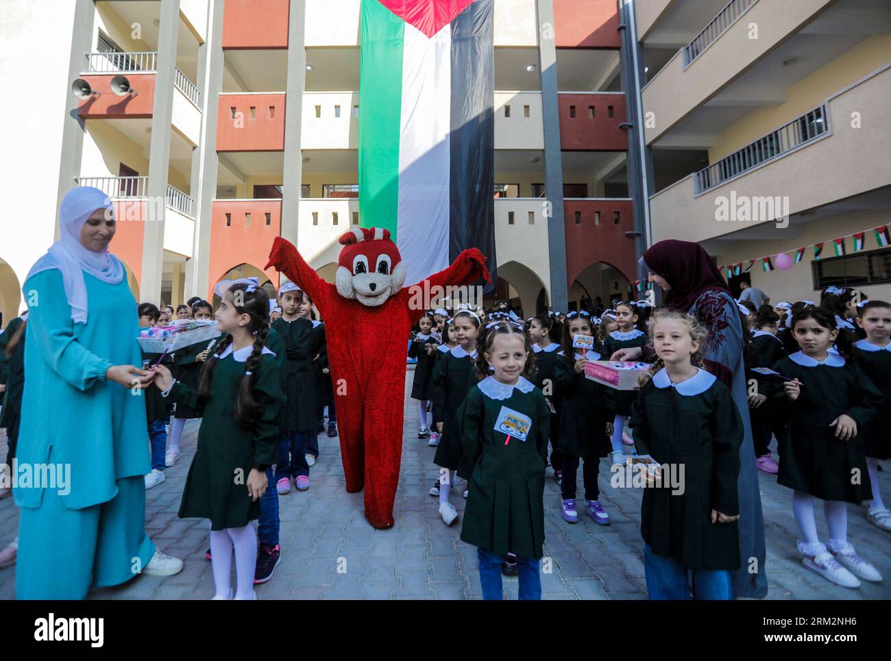 Gli studenti palestinesi prendono parte a uno spettacolo di clown durante le prove mattutine per il primo giorno a scuola del nuovo anno all'interno della loro scuola dell'Agenzia delle Nazioni Unite per il soccorso e l'occupazione (UNRWA) nella città di Gaza. Foto Stock