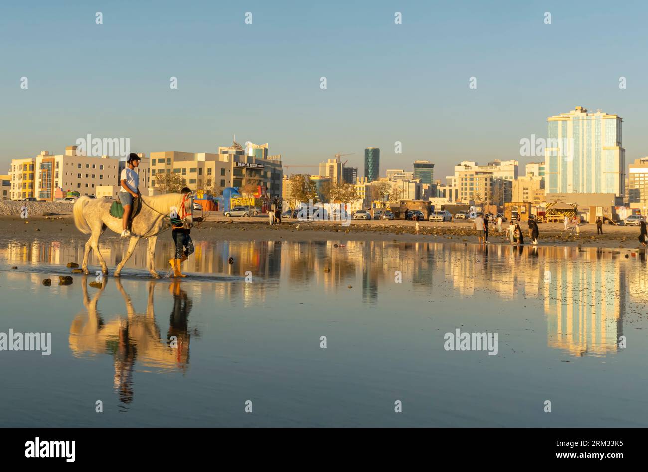 Equitazione guidata da un uomo alla spiaggia di Karbabad. Seef Bahrain Foto Stock