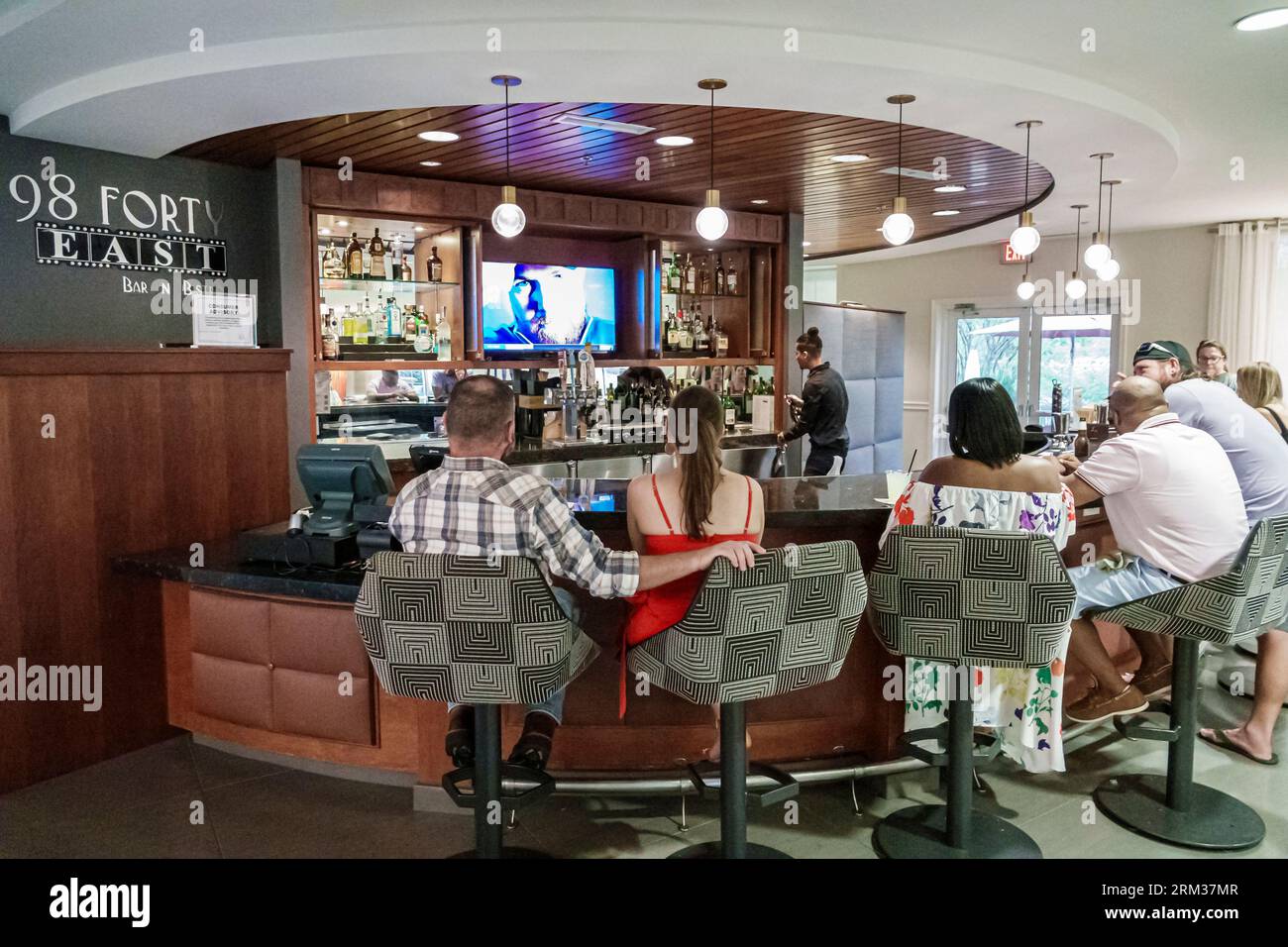 Jacksonville, Florida, Tapestry Park, Hotel Indigo Jacksonville-Deerwood Park, bar pub lounge con sedie girevoli, barman ospiti clienti, uomo uomo uomo, donna Foto Stock