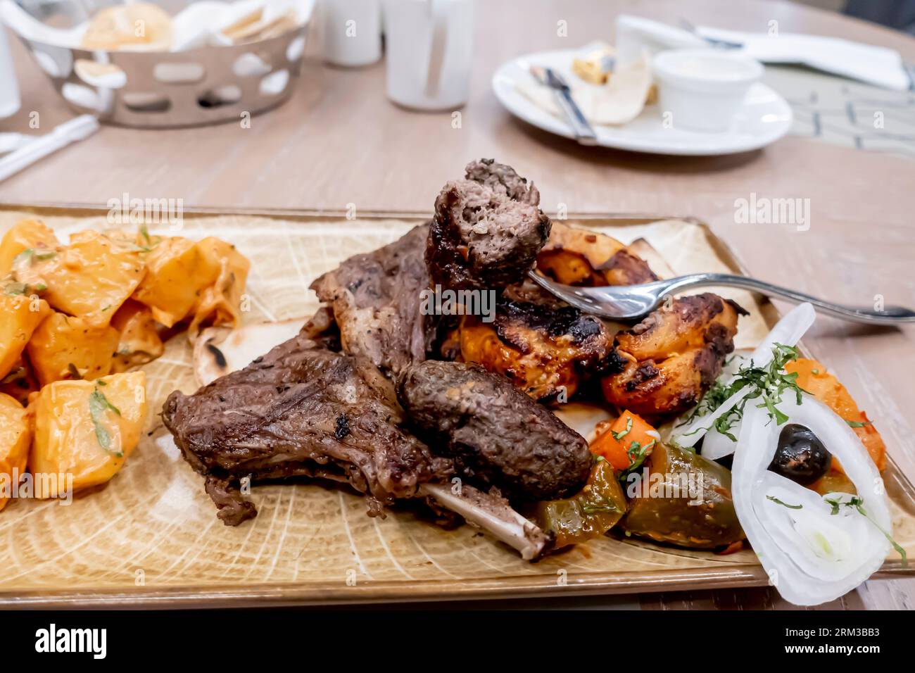 Grigliate miste di carne - costolette di agnello, kebab di pollo e manzo, patate arrosto alle erbe e verdure sottaceto - ristorante Crossroads Bahrain Foto Stock