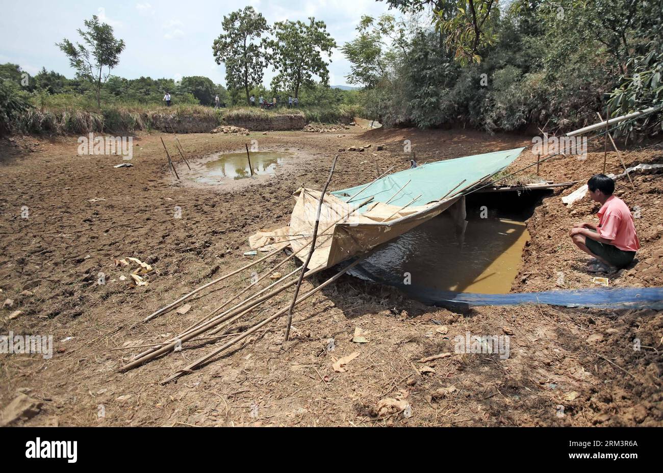 Bildnummer: 60303267 Datum: 02.08.2013 Copyright: imago/Xinhua Un agricoltore scava un piccolo stagno per salvare i pesci che muoiono in una piscina di pesca essiccata nella città di Yangjiaotang, contea di Qiyang, provincia di Hunan della Cina centrale, 2 agosto 2013. La provincia di Hunan è stata colpita dalla siccità più grave degli ultimi 10 anni da luglio, che ha causato la carenza di acqua potabile per circa 1,38 milioni di locali entro agosto 1. Le autorità locali hanno adottato misure per combattere la siccità. (Xinhua/li GA) (zwx) CHINA-HUNAN-QIYANG-SICCITÀ(CN) PUBLICATIONxNOTxINxCHN Gesellschaft Wetter Trockenheit Dürre xsp x0x 2013 quer premiumd 60303267 Foto Stock