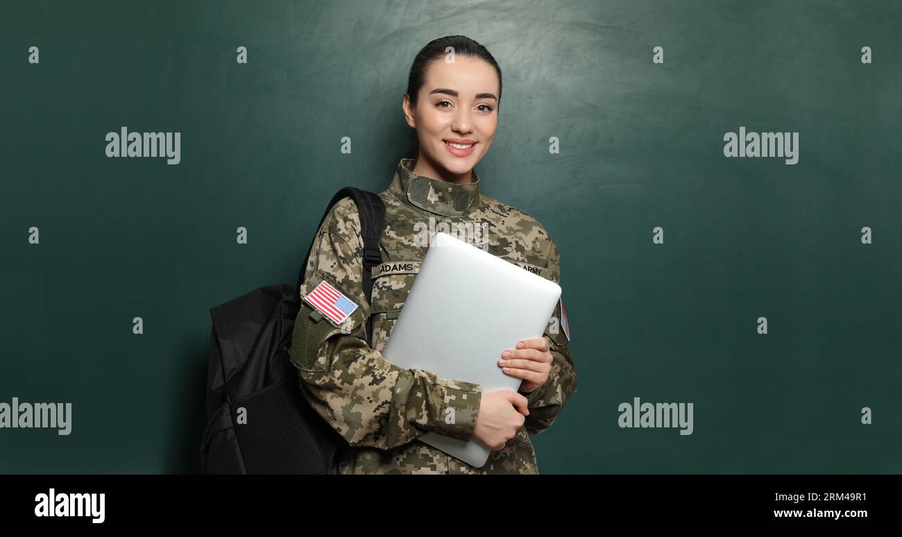 Educazione militare. Cadetto con zaino e laptop vicino alla lavagna verde Foto Stock