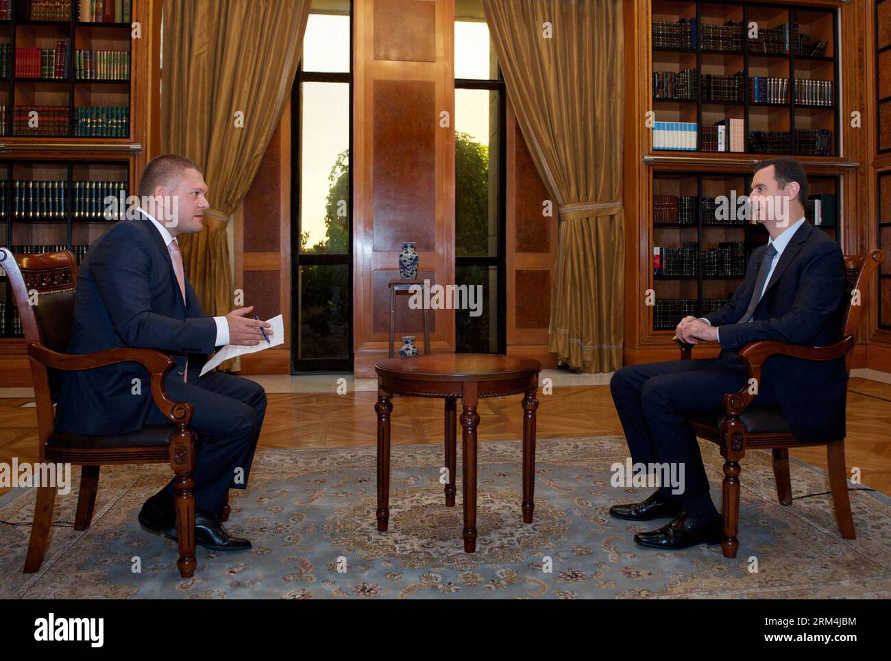 Bildnummer: 60471488 Datum: 12.09.2013 Copyright: imago/Xinhua (130913) -- DAMASCO, (Xinhua) -- il presidente siriano Bashar al-Assad (R) riceve un'intervista al canale Russia 24 a Damasco, capitale della Siria, su Spet.12, 2013. Il presidente siriano Bashar al-Assad ha affermato di aver accettato di mettere le armi chimiche sotto osservazione internazionale su richiesta della Russia e non a causa delle minacce americane, l'agenzia di stampa sana, gestita dallo Stato, ha riferito giovedì. Giovedì la Siria ha formalmente chiesto di aderire all'Organizzazione per la proibizione delle armi chimiche (OPCW), promettendo di rispettare immediatamente pienamente Foto Stock