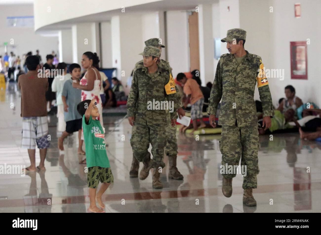 Bildnummer: 60491712 Datum: 17.09.2013 Copyright: imago/Xinhua (130918) -- GUERRERO, 17 settembre 2013 (Xinhua) -- Un ragazzo parla con elementi dell'esercito al Forum del Mundo Imperial Shelter ad Acapulco, Guerrero, Messico, il 17 settembre 2013. L'aeroporto rimane chiuso e i voli nazionali sono stati cancellati, a causa delle inondazioni che hanno raggiunto un'altezza di 4ft 11in, causate dalle piogge generate dall'uragano Ingrid che è stato degradato a tempesta, nel Golfo del Messico, e dalla tempesta tropicale Manuel nel Pacifico. L'aeroporto dovrebbe essere di nuovo operativo il martedì sera, secondo il pr locale Foto Stock