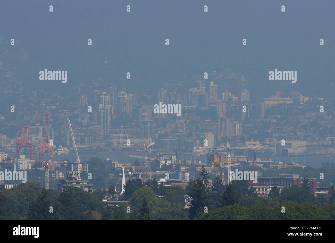 Vancouver, Canada. 26 agosto 2023. Gli edifici sono avvolti in foschia nel centro di Vancouver, British Columbia, Canada, 26 agosto 2023. La Metro Vancouver ha continuato un avviso sulla qualità dell'aria per la regione metropolitana di Vancouver sabato a causa dell'alta concentrazione di particolato fine causata dal fumo di incendi che si diffondono in tutta la Columbia Britannica. Crediti: Liang Sen/Xinhua/Alamy Live News Foto Stock