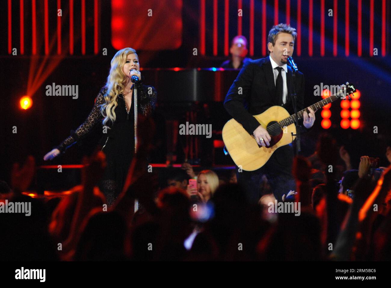 VANCOUVER, 18 ottobre 2013 (Xinhua) -- il cantante canadese Avril Lavigne (L) e il Chad Kroeger di Nickelback si esibiscono di fronte a circa 20.000 bambini delle scuole durante il quinto evento annuale Free the Children S We Day alla Rogers Arena di Vancouver, Canada, 18 ottobre 2013. We Day è il più grande evento di empowerment giovanile del suo genere che promuove la tolleranza e l'ispirazione per i giovani e incoraggia i giovani a impegnarsi nella risoluzione dei problemi mondiali di fame e libertà. (Xinhua/Sergei Bachlakov)(lrz) CANADA-VANCOUVER-FREE THE CHILDREN PUBLICATIONxNOTxINxCHN Vancouver OCT 18 2013 XINHUA Foto Stock