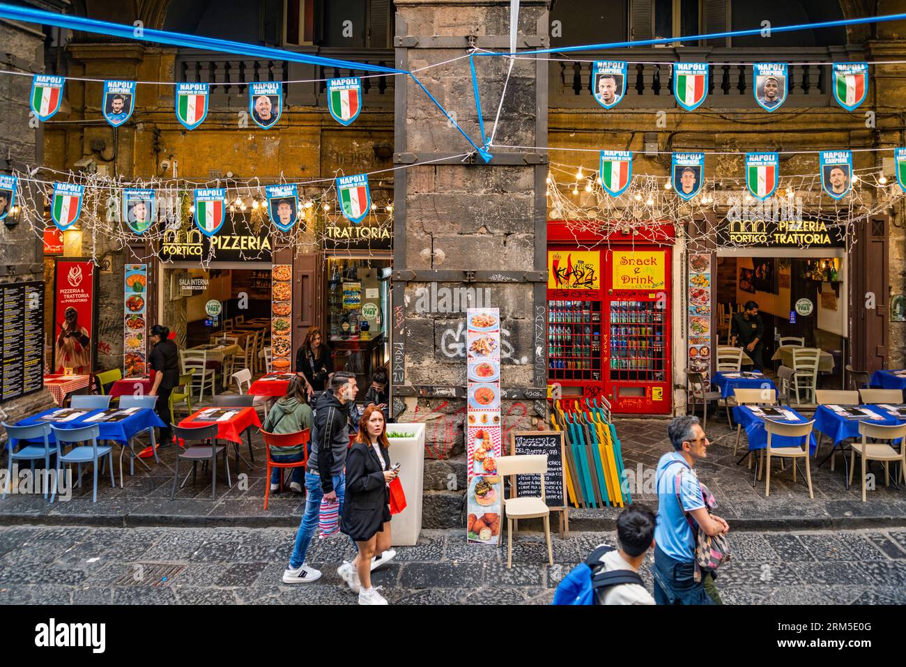 Il turista in via dei tribunali nel centro storico di Napoli con negozi e ristoranti nel backgorund Foto Stock