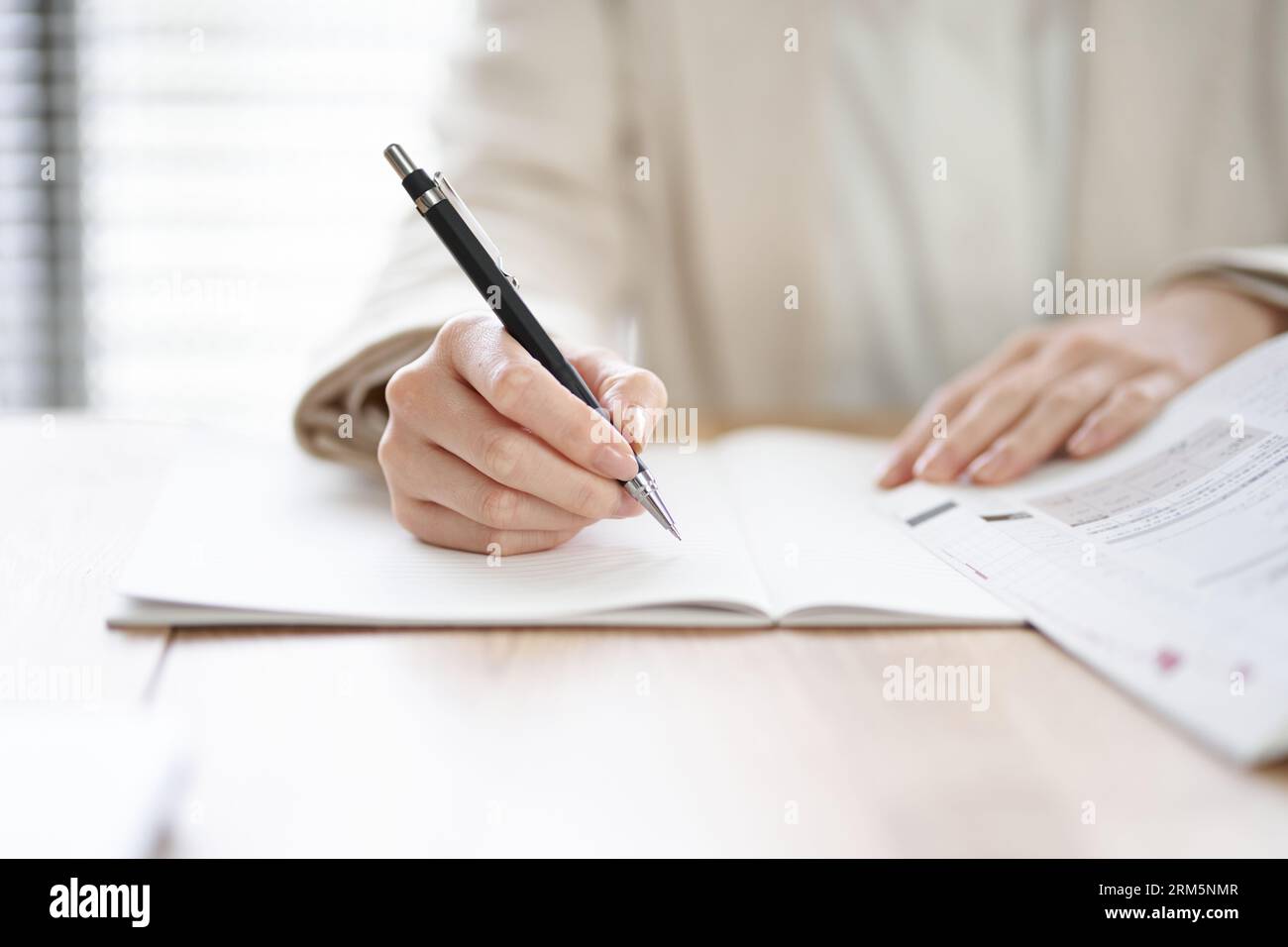 Mani di una donna asiatica che studia in uno spazio di coworking Foto Stock