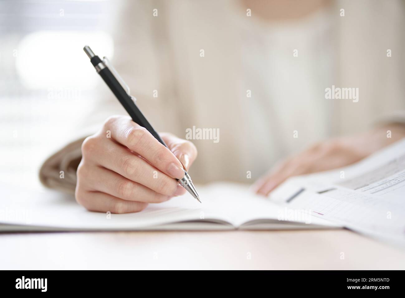 Mani di una donna asiatica che studia in uno spazio di coworking Foto Stock