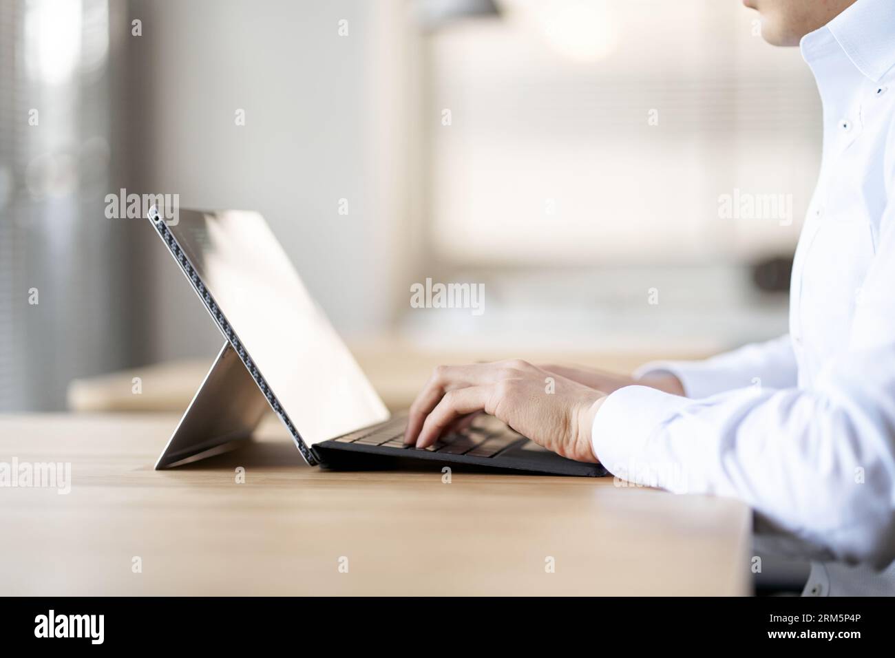 Uomo d'affari asiatico che lavora su un computer in uno spazio di coworking Foto Stock
