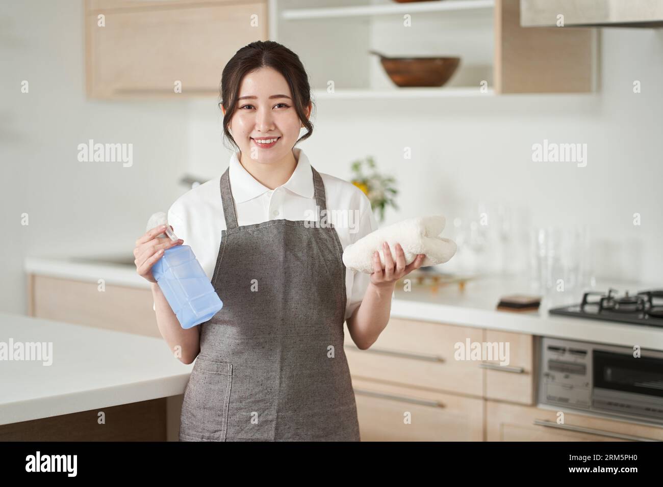 Donna asiatica che piega gli asciugamani e li mette via Foto Stock