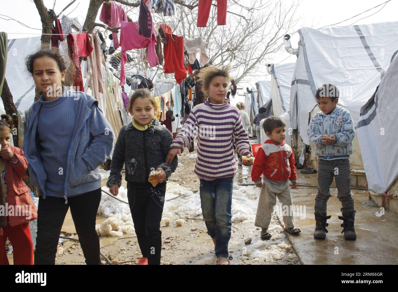 Bildnummer: 60823341 Datum: 12.12.2013 Copyright: imago/Xinhua i bambini camminano all'interno di un campo profughi nella Bekaa Valley, nel Libano orientale, dopo una tempesta di neve il 12 dicembre 2103. La tempesta di neve Alexa ha colpito il Libano martedì sera, portando la neve nelle zone più alte e la pioggia torrenziale altrove, accompagnata da forti venti.le Nazioni Unite e i suoi partner umanitari stanno intensificando gli sforzi di aiuto per gli oltre 800.000 rifugiati siriani in Libano che stavano tremando per le piogge, nevicate e temperature gelide mentre una feroce tempesta invernale si muove attraverso la regione, i funzionari delle Nazioni Unite hanno detto qui venerdì. (Xinhu Foto Stock