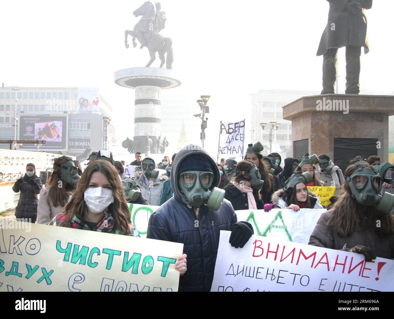 (131221) -- SKOPJE, 21 dicembre 2013 (Xinhua) -- gli attivisti ambientali macedoni che indossano maschere antigas partecipano a una protesta nella piazza principale di Skopje, capitale della Macedonia, il 21 dicembre 2013. Skopje e altre tre città macedoni hanno individuato un enorme inquinamento atmosferico nelle ultime due settimane, provocando il governo a emanare una serie di misure e raccomandazioni di protezione. L'aeroporto di Skopje ha cancellato quasi tutti i voli per gli aeroporti di Ohrid, Sofija e Belgrado in due giorni consecutivi a causa della nebbia e dello smog causati dall'inquinamento atmosferico. (Xinhua/Darko Duridanski) (srb) MACEDONIA-SKOPJE-PROTES Foto Stock
