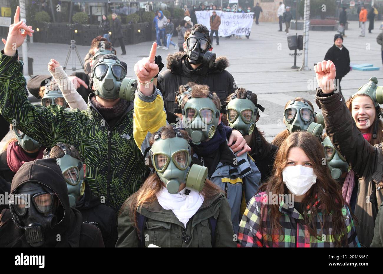 (131221) -- SKOPJE, 21 dicembre 2013 (Xinhua) -- gli attivisti ambientali macedoni che indossano maschere antigas partecipano a una protesta nella piazza principale di Skopje, capitale della Macedonia, il 21 dicembre 2013. Skopje e altre tre città macedoni hanno individuato un enorme inquinamento atmosferico nelle ultime due settimane, provocando il governo a emanare una serie di misure e raccomandazioni di protezione. L'aeroporto di Skopje ha cancellato quasi tutti i voli per gli aeroporti di Ohrid, Sofija e Belgrado in due giorni consecutivi a causa della nebbia e dello smog causati dall'inquinamento atmosferico. (Xinhua/Darko Duridanski) (srb) MACEDONIA-SKOPJE-PROTES Foto Stock