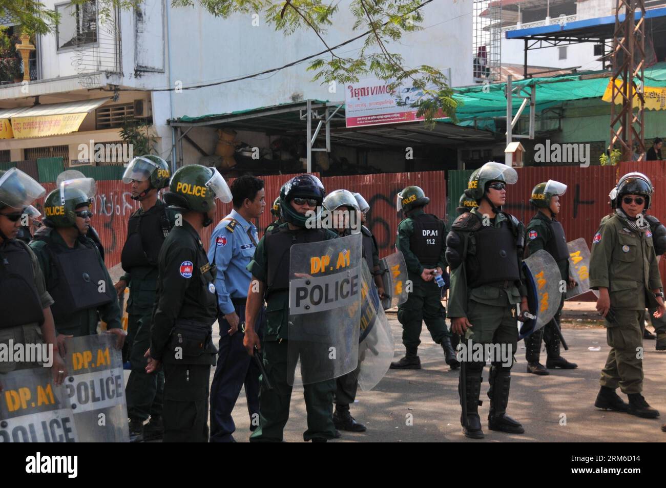 (140104) -- PHNOM PENH, 4 gennaio 2014 (Xinhua) -- i poliziotti stanno di guardia mentre il personale ufficiale sgomberano la base di raduno dei manifestanti dell'opposizione al Parco della democrazia a Phnom Penh, Cambogia, 4 gennaio 2014. Le autorità cambogiane hanno disperso i manifestanti dell'opposizione dalla loro base di raduno nella capitale e hanno fermato ulteriori proteste contro il Premier del regno, un giorno dopo che la polizia ha lanciato una letale repressione contro i lavoratori dell'abbigliamento in sciopero.(Xinhua/li Hong)(zhf) CAMBODIA-PHNOM PENH-PROTESTA-DISPERSE PUBLICATIONxNOTxINxCHN Phnom Penh 4 gennaio 2014 i poliziotti di XINHUA sono di guardia come personale ufficiale Foto Stock