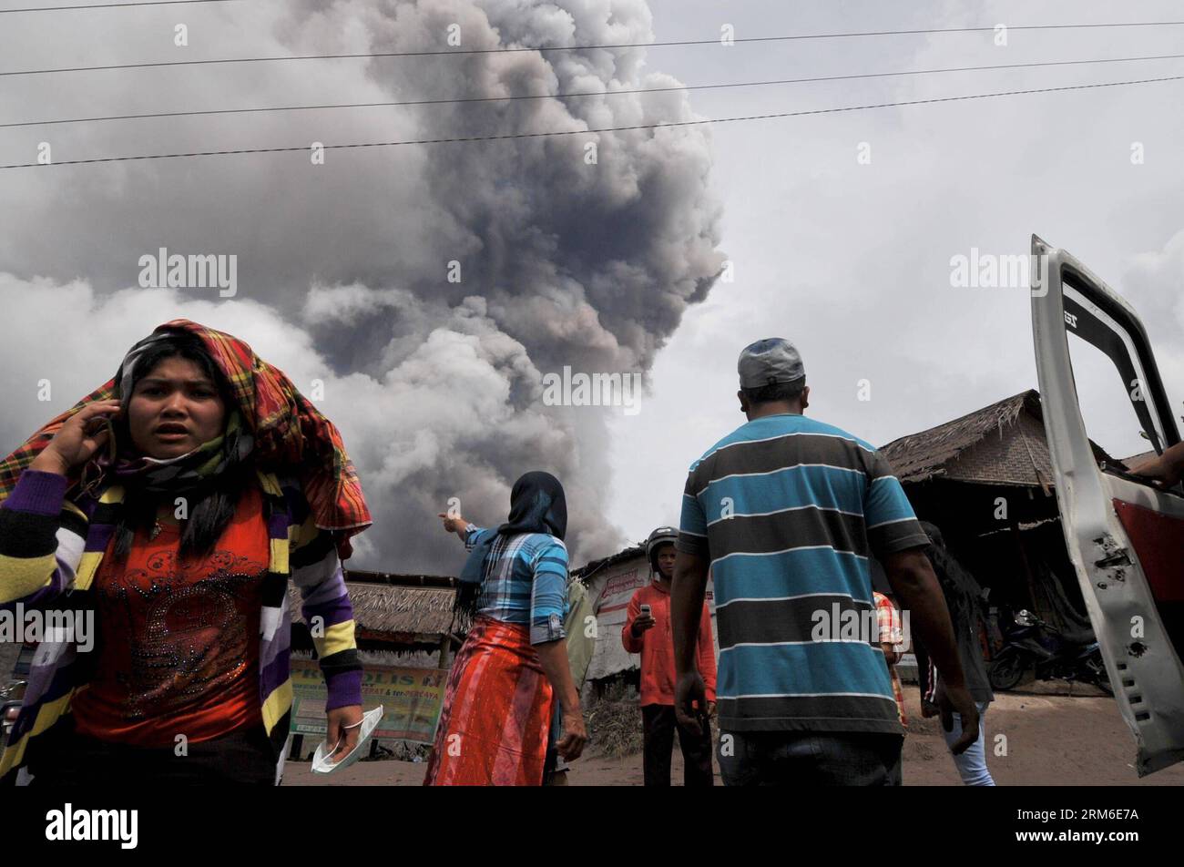 (140107) -- SUMATRA SETTENTRIONALE, 7 gennaio 2014. (Xinhua) -- la gente guarda come il Monte Sinabung lancia materiali vulcanici durante un'eruzione a Sumatra settentrionale, Indonesia, 7 gennaio 2014. Oltre 21.800 persone hanno cercato rifugio in 33 rifugi nel distretto di Karo nella provincia di Sumatra settentrionale, mentre il vulcano Sinabung ha continuato a spargere cenere e lava lunedì, ha detto un funzionario indonesiano. (Xinhua/Agung Kuncahya B.) INDONESIA-SUMATRA SETTENTRIONALE-MONTE SINABUNG-ERUPTION PUBLICATIONxNOTxINxCHN Sumatra settentrionale 7 gennaio 2014 le celebrità di XINHUA guardano come il Monte Sinabung lancia materiale vulcanico durante l'eruzione nel nord di Sumatra indonesiano Foto Stock