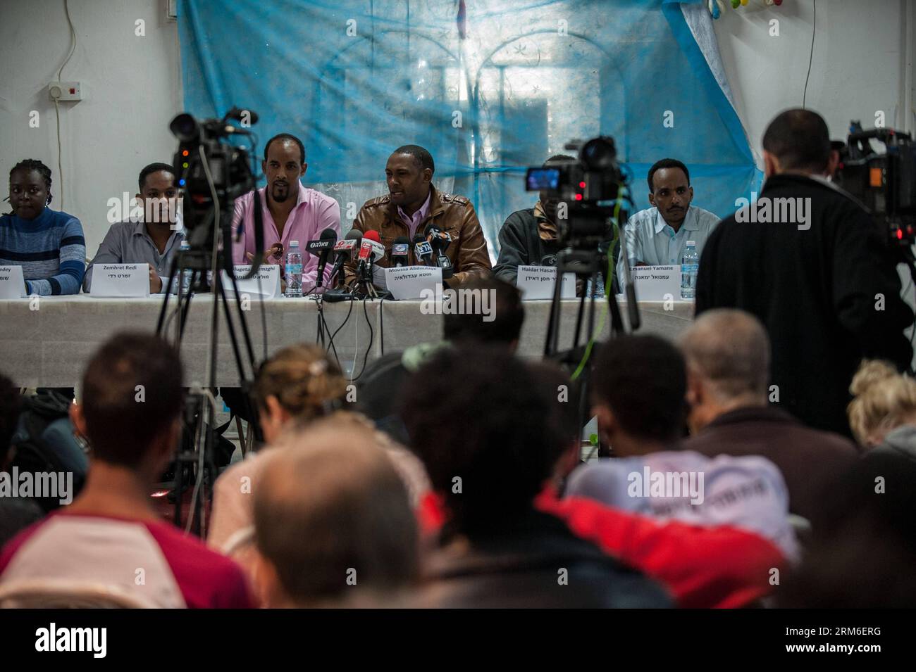 (140108) -- TEL AVIV, (Xinhua) -- Moussa Abdoulaye (4th L), un richiedente asilo del Darfur, si rivolge a una conferenza stampa a Tel Aviv, Israele, il 7 gennaio 2014. I richiedenti asilo in Israele hanno dichiarato che continueranno a scioperare fino a nuovo avviso, mentre la loro lotta per i diritti dei rifugiati entrerà nel suo terzo giorno, i rappresentanti della comunità hanno dichiarato martedì in una conferenza stampa a Tel Aviv. Decine di migliaia di richiedenti asilo sono in sciopero da domenica. Sono scesi per le strade di Tel Aviv e hanno marciato verso le ambasciate statunitensi ed europee in Israele in un appello per la pressione internazionale per annullare l'Anti-Israele Foto Stock