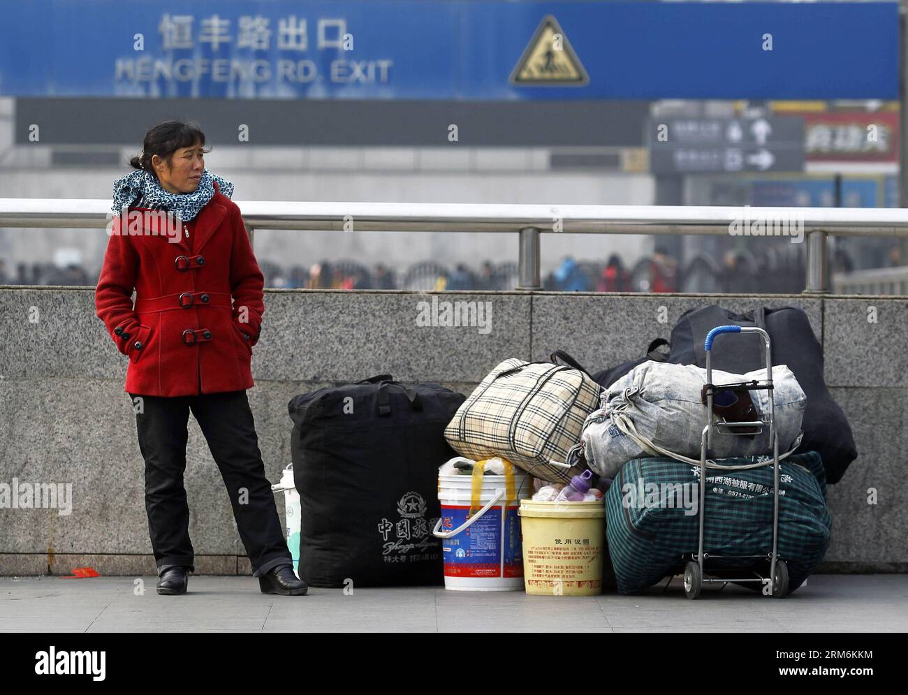 (140118) -- SHANGHAI, 18 gennaio 2014 (Xinhua) -- il lavoratore migrante Hu Gaihua attende fuori dalla stazione ferroviaria di Shanghai, East China S Shanghai, 18 gennaio 2014. Un viaggio in treno a lunga distanza non può scoraggiare il desiderio delle persone di riunirsi con i familiari durante il capodanno lunare cinese. Hanno provato tutti i mezzi per ottenere un biglietto per tornare alla città natale prima del festival. (Xinhua/Ding Ting) (cjq) CINA-SHANGHAI-LUNAR NEW YEAR TRAVEL RUSH (CN) PUBLICATIONxNOTxINxCHN Shanghai Jan 18 2014 XINHUA Immigrant Worker HU attende fuori dalla stazione ferroviaria di Shanghai East China S Shanghai Jan 18 2014 A. Foto Stock