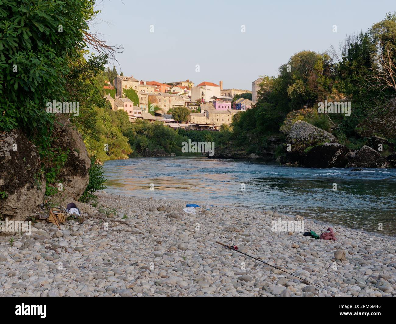 Pebbled Beach lungo le rive del fiume Neretva con il centro storico di Mostar alle spalle, Bosnia ed Erzegovina, 26 agosto 2023. Foto Stock