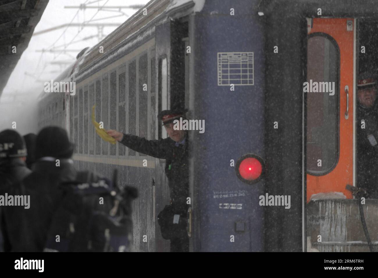 BUCAREST, 29 gennaio 2014 (Xinhua) -- Un meccanico del treno segnala mentre il treno arriva nella stazione ferroviaria principale di Bucarest, capitale della Romania, 29 gennaio 2014. Una nuova forte tempesta di neve mercoledì ha iniziato a colpire la capitale della Romania, così come il sud e il sud-est. Le autorità rumene hanno dichiarato lo stato di emergenza in altre quattro contee di Ialomita, Calarasi, Constanta e Tulcea per consentire una migliore risposta all'attuale tempesta di neve. (Xinhua/Gabriel Petrescu)(Aceria) ROMANIA-BUCAREST-EMERGENZA NEVE PUBLICATIONxNOTxINxCHN Bucarest Jan 29 2014 XINHUA un treno meccanico segnale mentre il treno arr Foto Stock