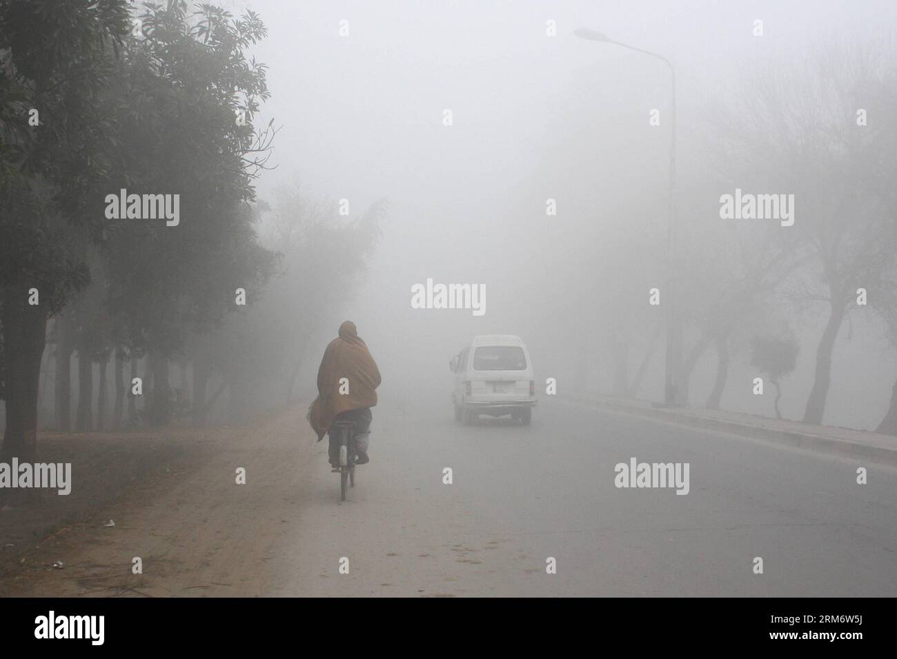 (140131) -- LAHORE, 31 gennaio 2014 (Xinhua) -- Un uomo cavalca la bicicletta nella nebbia pesante nel Pakistan orientale a Lahore, 31 gennaio 2014. Almeno quattro persone sono rimaste uccise e altre 27 ferite in incidenti stradali legati alla nebbia in diverse parti della provincia del Punjab, hanno riferito i media locali. (Xinhua/Jamil Ahmed)(ctt) PAKISTAN-LAHORE-WEATHER-FOG PUBLICATIONxNOTxINxCHN Lahore gennaio 31 2014 XINHUA a Man Rides BICYCLE in Heavy Fog nel Pakistan orientale A Lahore gennaio 31 2014 almeno quattro celebrità sono state UCCISE e altre 27 ferite in incidenti stradali LEGATI ALLA nebbia in diverse parti della provincia del Punjab Repor dei media locali Foto Stock