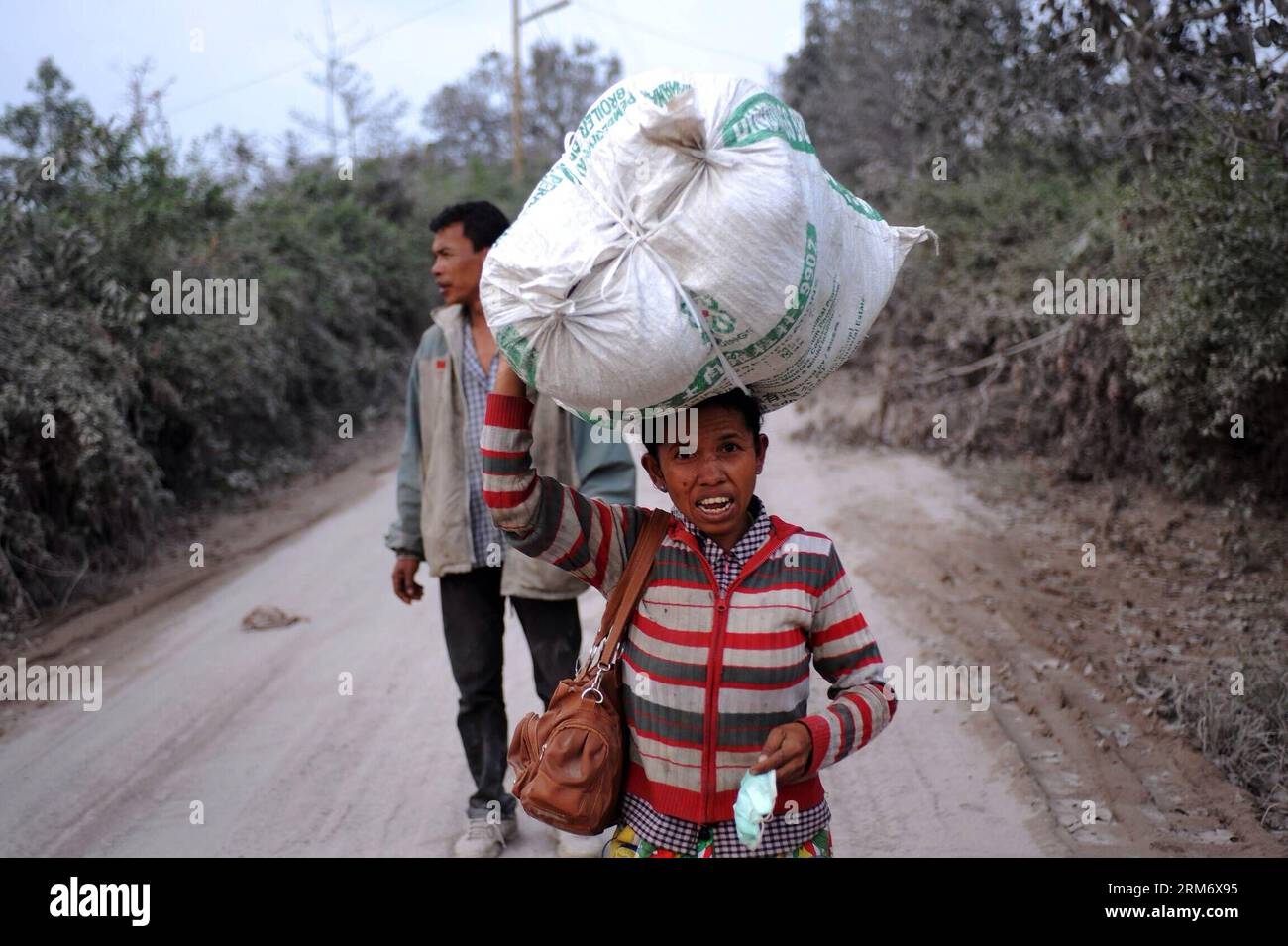 (140202) -- GIACARTA, 2 febbraio 2014 (Xinhua) -- i residenti locali camminano sulla strada che piena di cenere dall'eruzione vulcanica di Sinabung in un villaggio nel Sumatera settentrionale, Indonesia, 2 febbraio 2014. Un totale di 14 persone sono state uccise e altre tre ferite nella nuova eruzione del vulcano del Monte Sinabung sabato, hanno detto i funzionari. (Xinhua/veri Sanovri)(Aceria) INDONESIA-SUMATERA SETTENTRIONALE-SINABUNG-VULCANO ERUZIONE PUBLICATIONxNOTxINxCHN Giacarta 2 febbraio 2014 XINHUA residenti locali camminano SULLA strada Thatcher pieno di cenere dal vulcano Sinabung eruzione IN un villaggio nel nord dell'Indonesia 2 febbraio 2014 un totale di 14 Celebriti Foto Stock