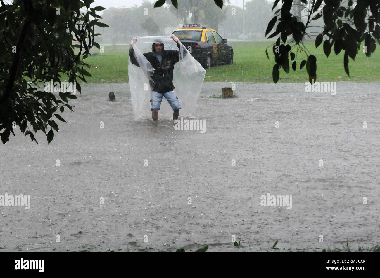 Un uomo cammina sotto la pioggia battente in una strada allagata a Buenos Aires, capitale dell'Argentina, il 7 febbraio 2014. Le calamità di venerdì mattina a Buenos Aires hanno inondato le aree dei comuni di la Plata ed Ensenada e causato l'evacuazione di persone nella cittadina di Berisso, secondo la stampa locale. (Xinhua/Leonardo Zavattaro/TELAM) (rt) ARGENTINA-BUENOS AIRES-AMBIENTE-CLIMA PUBLICATIONxNOTxINxCHN un uomo cammina in Heavy Rain SU una strada allagata a Buenos Aires capitale dell'Argentina IL 7 febbraio 2014 da venerdì mattina a Buenos Aires hanno inondato le aree di la Plata e Ensenada Foto Stock