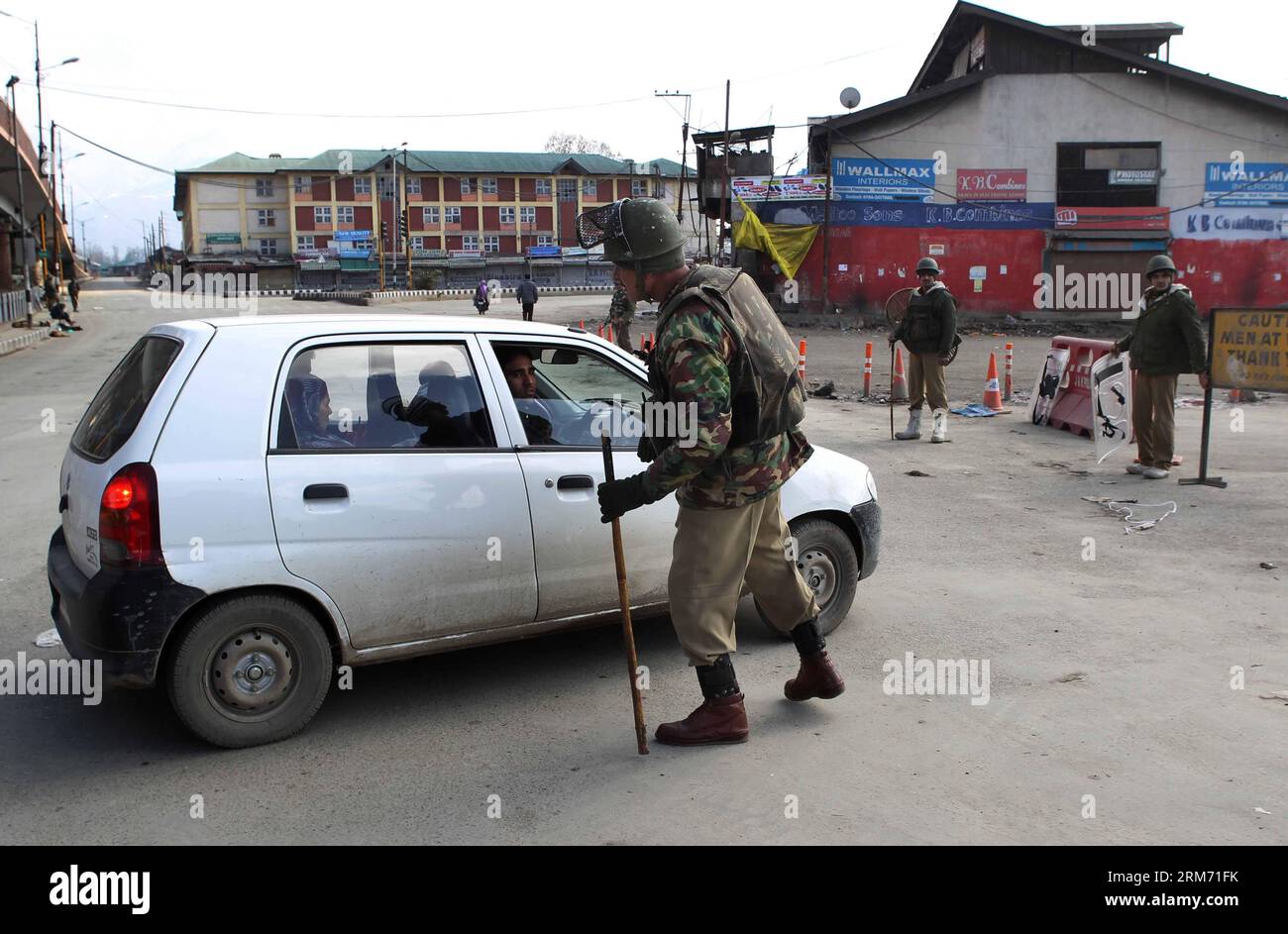 (140209) -- SRINAGAR, 9 febbraio 2014 (Xinhua) -- un equipaggio paramilitare indiano ferma un'auto durante le restrizioni a Srinagar, la capitale estiva del Kashmir controllato dagli indiani, 9 febbraio 2014. Le autorità domenica hanno imposto restrizioni nelle aree dominate dai musulmani del Kashmir controllato dagli indiani per prevenire proteste e scontri nel primo anniversario dell'esecuzione di Mohammed Afzal Guru condannato per attacco al parlamento indiano, hanno detto i funzionari. (Xinhua/Javed Dar) KASHMIR-SRINAGAR-PROTEST PUBLICATIONxNOTxINxCHN Srinagar 9 febbraio 2014 XINHUA a Indian paramilitare Trooper ferma un'auto durante le restrizioni a Srinagar th Foto Stock