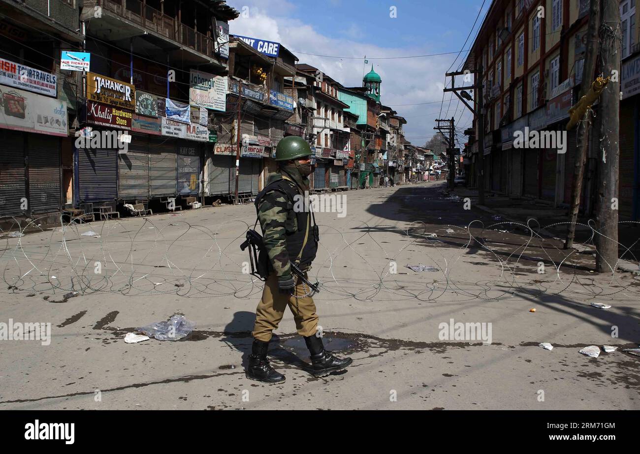 (140209) -- SRINAGAR, 9 febbraio 2014 (Xinhua) -- un gruppo paramilitare indiano si trova a guardia in un mercato chiuso durante le restrizioni a Srinagar, la capitale estiva del Kashmir controllato dagli indiani, 9 febbraio 2014. Le autorità domenica hanno imposto restrizioni nelle aree dominate dai musulmani del Kashmir controllato dagli indiani per prevenire proteste e scontri nel primo anniversario dell'esecuzione di Mohammed Afzal Guru condannato per attacco al parlamento indiano, hanno detto i funzionari. (Xinhua/Javed Dar) KASHMIR-SRINAGAR-PROTEST PUBLICATIONxNOTxINxCHN Srinagar 9 febbraio 2014 XINHUA a Indian paramilitare Trooper sta di guardia in una M chiusa Foto Stock