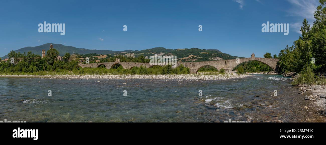 Vista panoramica sull'antico ponte in pietra di Bobbio, in Italia, in una calda giornata di sole Foto Stock