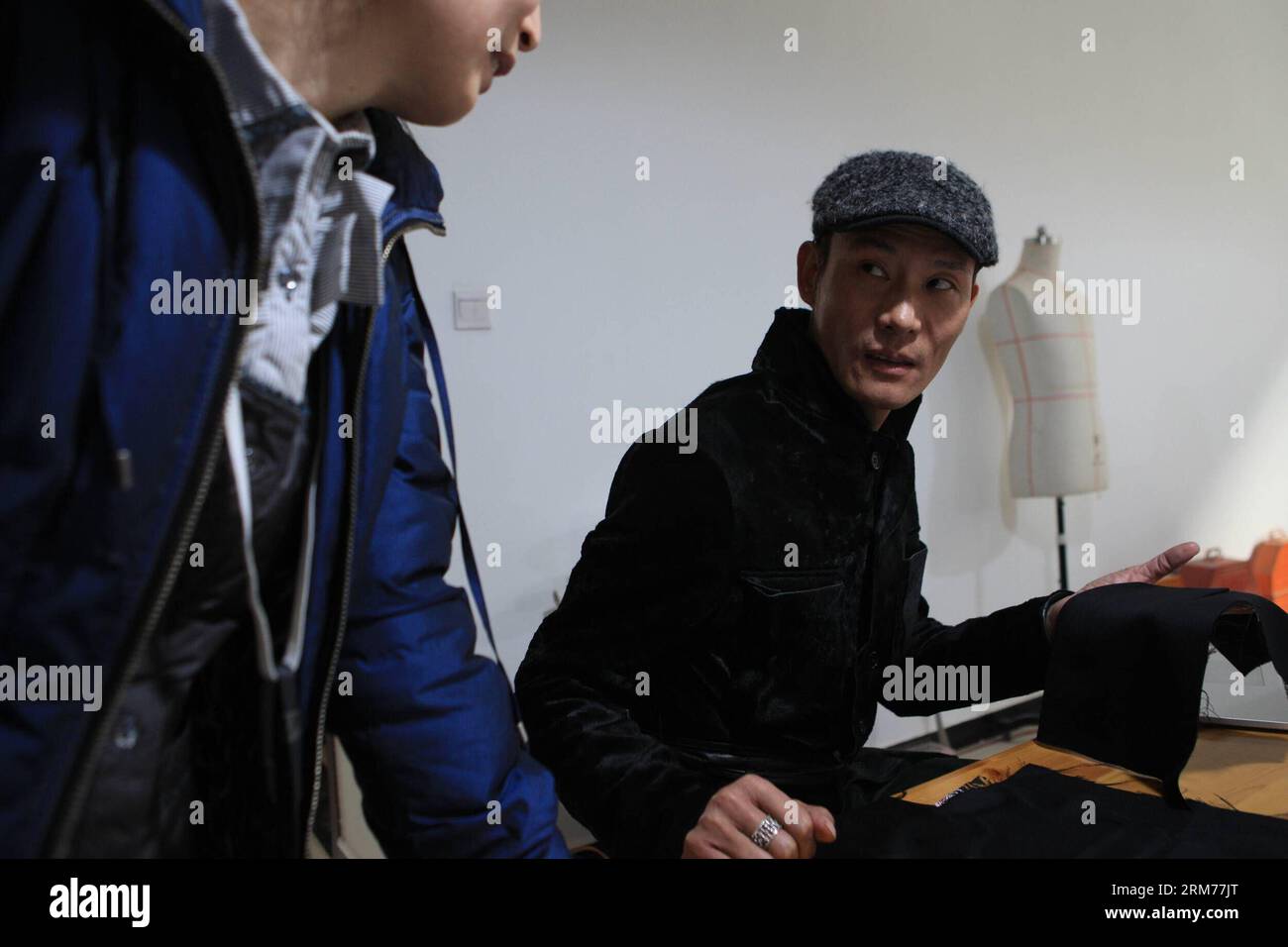(140217) -- PECHINO, 17 febbraio 2014 (Xinhua) -- il designer Laurence Xu discute con una sarta delle sue creazioni a Pechino, capitale della Cina, 16 febbraio 2014. Xu, uno stilista di Shandong, nato in Cina, con sede a Parigi, mostrerà le sue nuove creazioni alla settimana della moda di Parigi a luglio. (Xinhua/Liu Changlong) (wf) CHINA-BEIJING-FASHION-DESIGNER-LAURENCE XU (CN) PUBLICATIONxNOTxINxCHN Pechino 17 febbraio 2014 i designer di XINHUA Laurence Xu discute con una sarta delle sue creazioni a Pechino capitale della Cina 16 febbraio 2014 Xu a Shan Dong China Born Paris Stars Will Show His New Creations AT the Paris Foto Stock