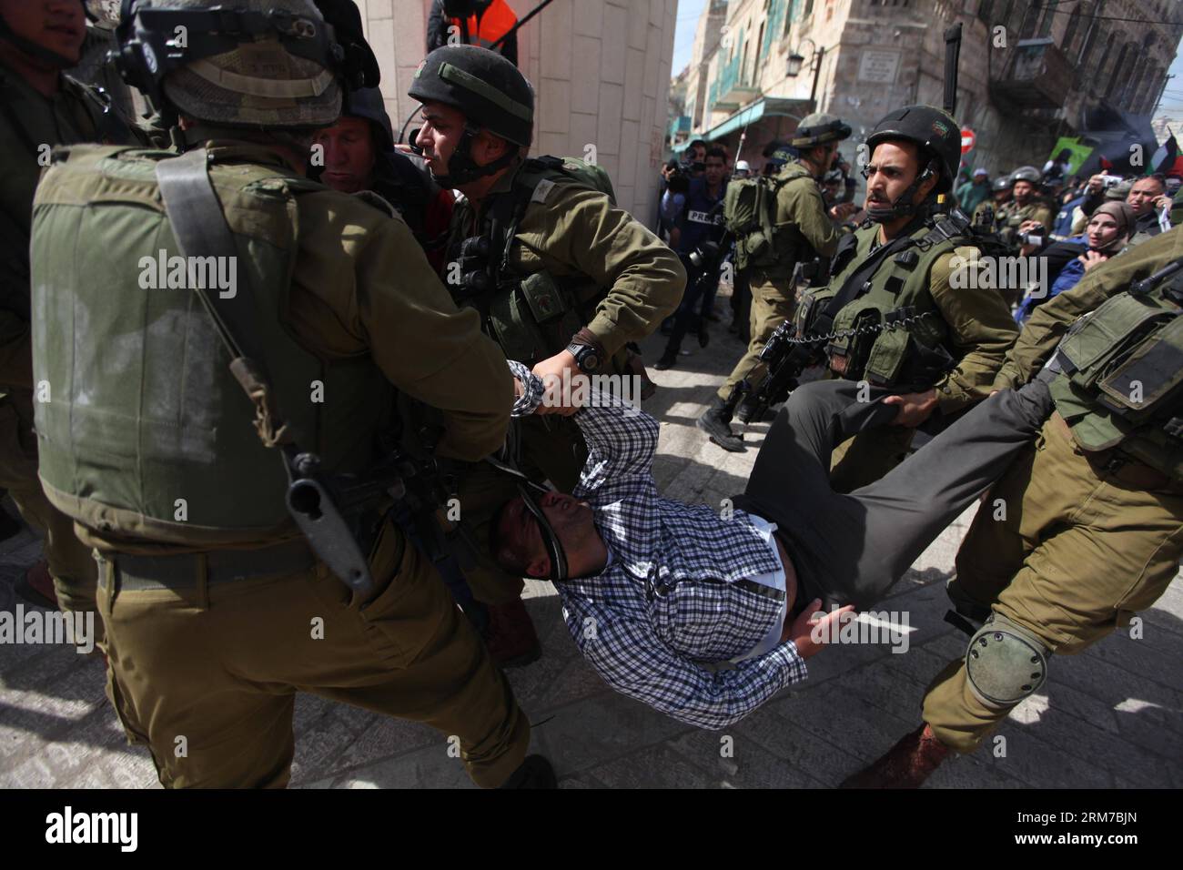 (140222) -- HEBRON, 22 febbraio 2014 (Xinhua) -- i soldati israeliani arrestano un manifestante palestinese nella città di Hebron in Cisgiordania il 21 febbraio 2014, durante una manifestazione che chiedeva di aprire la strada di al-Shuhada, parzialmente chiusa dopo un massacro della moschea del 1994 quando un colono sparò e uccise 29 fedeli musulmani. (Xinhua/Mamoun Wazwaz) MIDEAST-HEBRON-CLASHES PUBLICATIONxNOTxINxCHN Hebron 22 febbraio 2014 i soldati israeliani XINHUA arrestano un protestore PALESTINESE nella città di Hebron IN CISGIORDANIA IL 21 febbraio 2014 durante una dimostrazione che chiama ad aprire al Shuhada Street che ha parzialmente chiuso Aft Foto Stock