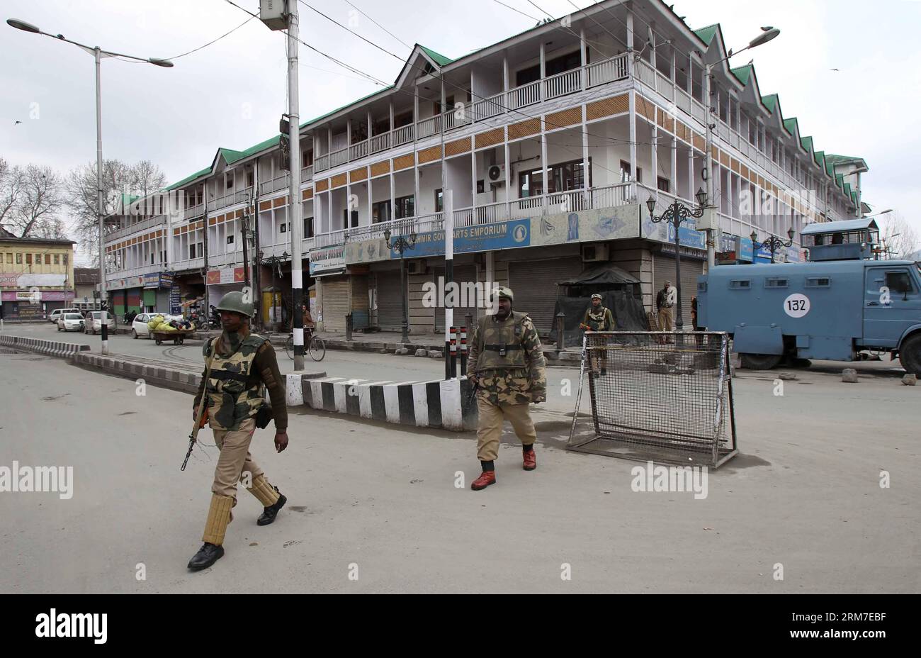 (140228) -- SRINAGAR, 28 febbraio 2014 (Xinhua) -- le truppe paramilitari indiane camminano in un mercato chiuso durante lo sciopero a Srinagar, capitale estiva del Kashmir controllato dagli indiani, il 28 febbraio 2014. Un arresto è stato osservato dalle aree a maggioranza musulmana del Kashmir controllato dagli indiani in seguito alla chiamata dei gruppi separatisti del Kashmir che cercavano l'identificazione di sette sospetti militanti uccisi dall'esercito indiano lunedì nel distretto di Kupwara, a circa 125 km a nord-ovest della città di Srinagar. Le proteste scoppiarono nella zona dopo che i civili sostenevano che gli uomini uccisi fossero civili. La polizia non ha identificato l'sl Foto Stock