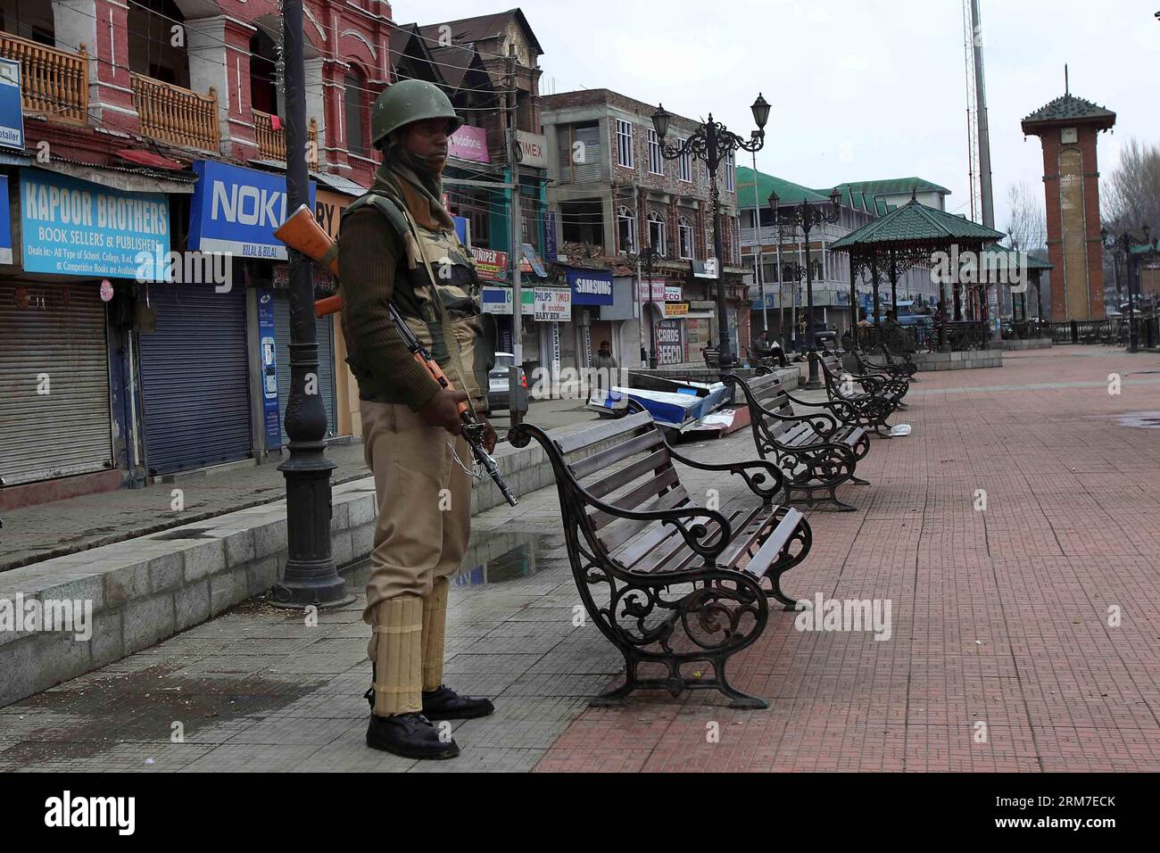 (140228) -- SRINAGAR, 28 febbraio 2014 (Xinhua) -- un'armata paramilitare indiana è in guardia in un mercato chiuso durante lo sciopero a Srinagar, capitale estiva del Kashmir controllato dagli indiani, il 28 febbraio 2014. Un arresto è stato osservato dalle aree a maggioranza musulmana del Kashmir controllato dagli indiani in seguito alla chiamata dei gruppi separatisti del Kashmir che cercavano l'identificazione di sette sospetti militanti uccisi dall'esercito indiano lunedì nel distretto di Kupwara, a circa 125 km a nord-ovest della città di Srinagar. Le proteste scoppiarono nella zona dopo che i civili sostenevano che gli uomini uccisi fossero civili. La polizia non ha la sua identita' Foto Stock