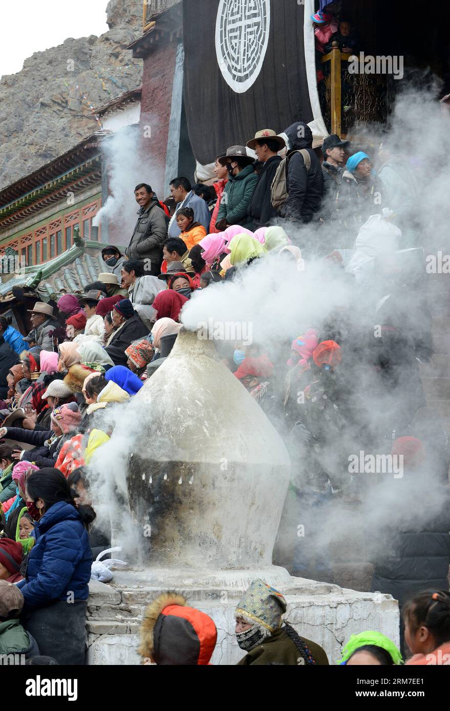 (140228) -- LHASA, 28 febbraio 2014 (Xinhua) -- i buddisti tibetani guardano un rituale di danza Cham tenuto per celebrare l'imminente Losar al monastero di Tsurphu nella contea di Doilungdeqen di Lhasa, capitale della regione autonoma del Tibet della Cina sud-occidentale, 28 febbraio 2014. La danza Cham è un rituale eseguito dai monaci buddisti tibetani per esorcizzare gli spiriti maligni. I ballerini indossano maschere di vari animali e figure mitiche mentre si esibiscono con l'accompagnamento della musica religiosa. Al monastero di Tsurphu, una base principale della scuola Kagyu nel buddismo tibetano, la danza Cham viene solitamente eseguita due giorni prima della L Foto Stock