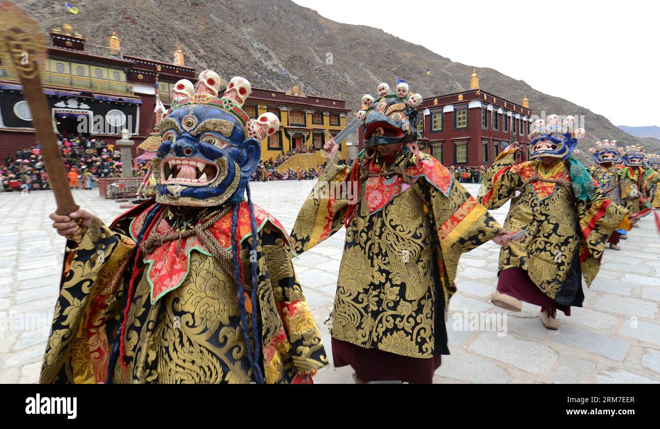 (140228) -- LHASA, 28 febbraio 2014 (Xinhua) -- i buddisti tibetani mascherati si esibiscono durante un rituale di danza Cham tenuto per celebrare l'imminente Losar al monastero di Tsurphu nella contea di Lhasa, capitale della regione autonoma del Tibet della Cina sud-occidentale, 28 febbraio 2014. La danza Cham è un rituale eseguito dai monaci buddisti tibetani per esorcizzare gli spiriti maligni. I ballerini indossano maschere di vari animali e figure mitiche mentre si esibiscono con l'accompagnamento della musica religiosa. Al monastero di Tsurphu, una base principale della scuola Kagyu nel buddhismo tibetano, la danza Cham viene solitamente eseguita due giorni Foto Stock