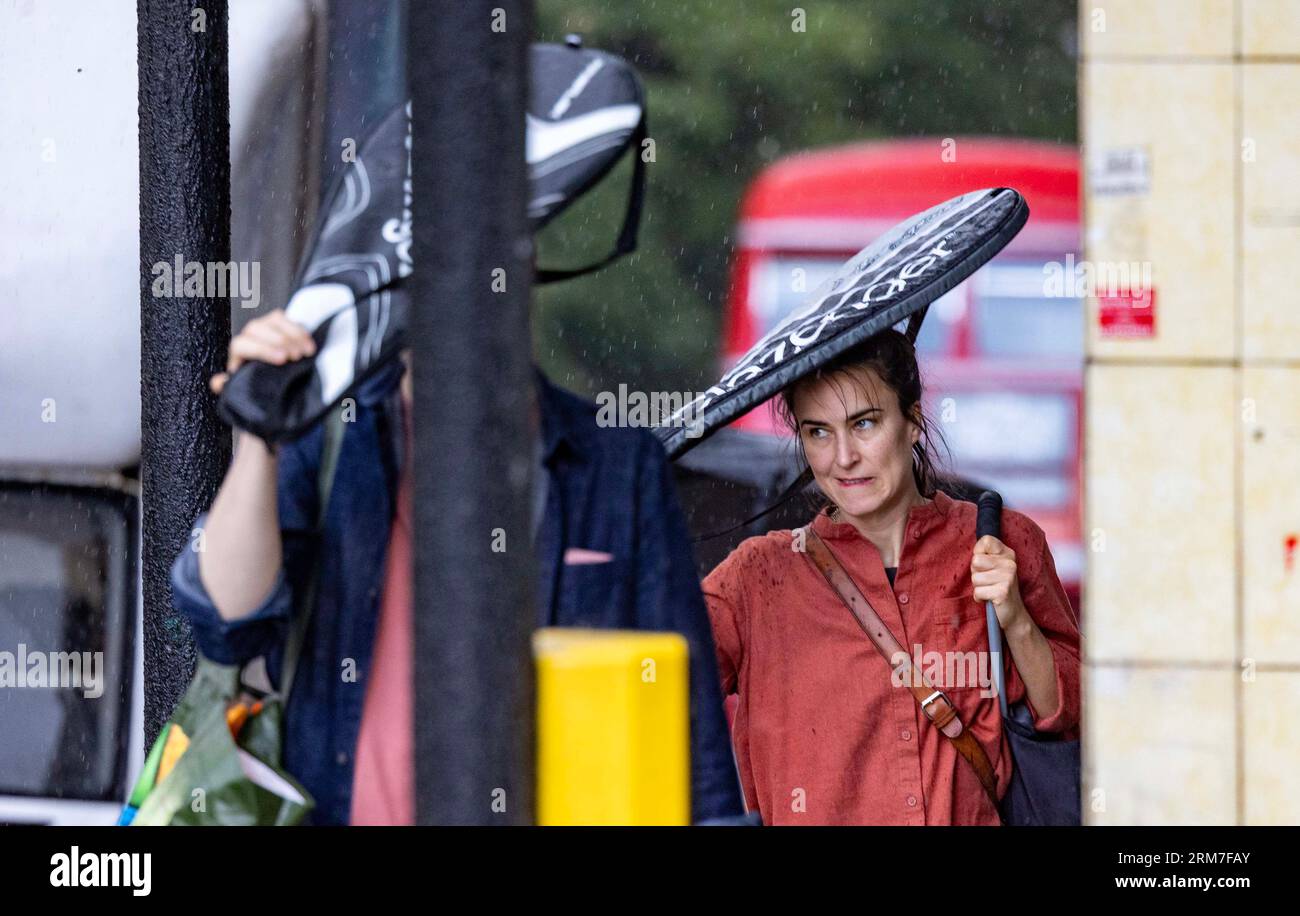 PIC Shows: Fulmini e temporali hanno colpito la zona nord di Londra durante le festività di August Bank oggi, rifugi improvvisati le persone vestite per l'estate si sono inzuppate. Foto Stock