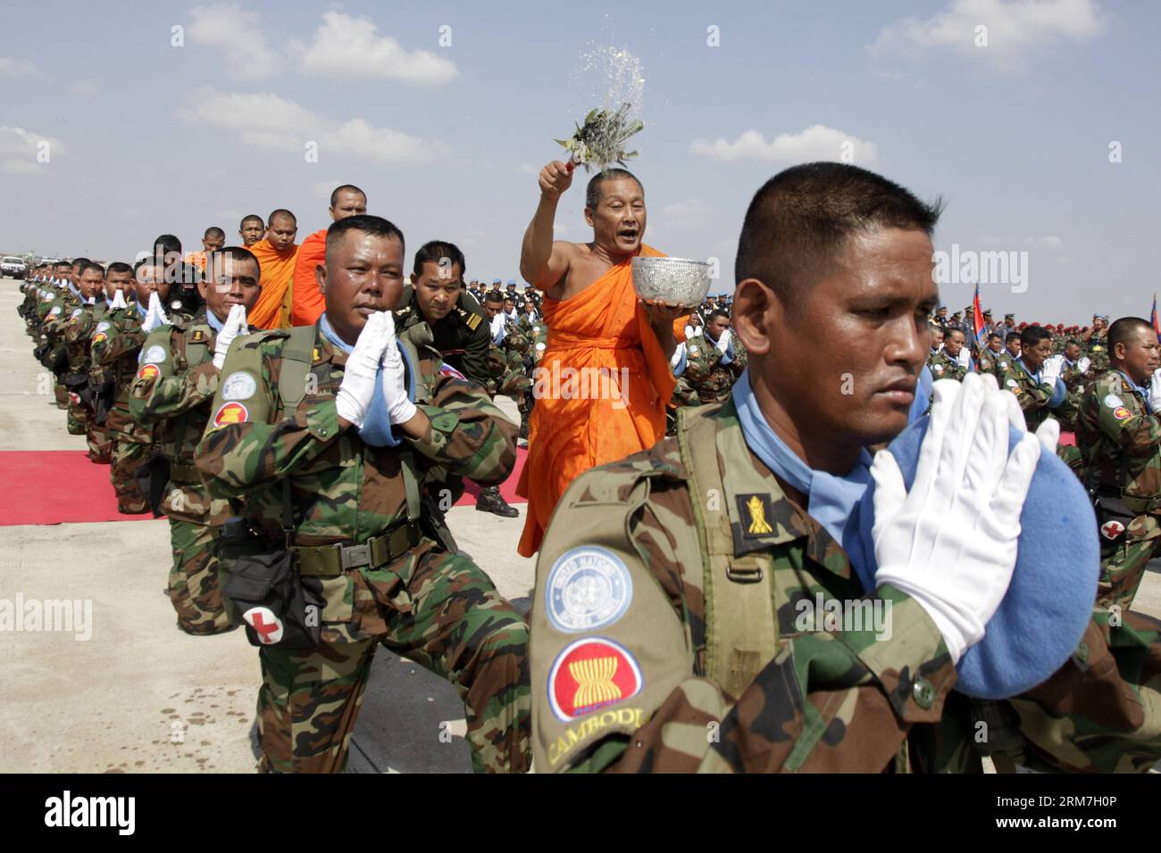 (140227) --PHNOM PENH, Feb. 27, 2014 (Xinhua) -- monaci buddisti spruzzano acqua Santa sulle forze di pace cambogiane presso la base militare di Phnom Penh, Cambogia, 27 Feb. 2014. Giovedì la Cambogia ha iniziato a inviare il suo primo lotto di 309 soldati per unirsi a una missione di pace delle Nazioni Unite nella nazione dell'Africa occidentale del Mali, lacerata dal conflitto. (Xinhua/Phearum)(zjl) CAMBOGIA-PHNOM PENH-TRUPPE-MISSIONE DI MANTENIMENTO DELLA PACE PUBLICATIONxNOTxINxCHN Foto Stock