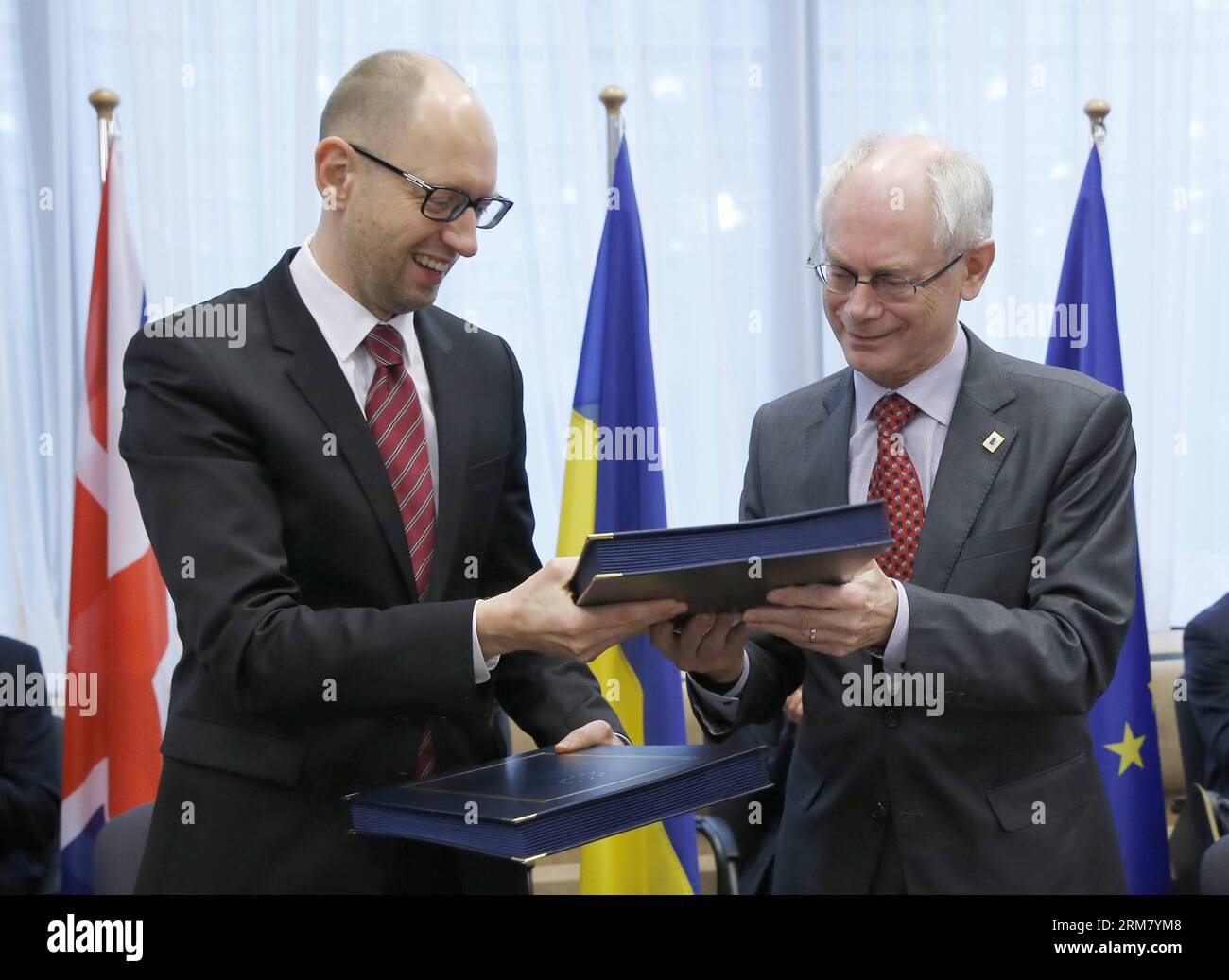 BRUXELLES, il primo ministro ucraino Arseniy Yatsenyuk (L) e il presidente del Consiglio europeo Herman Van Rompuy si scambiano i fascicoli delle disposizioni politiche dell'accordo di associazione UE-Ucraina nel corso di una cerimonia di firma durante il vertice UE presso la sede centrale dell'UE a Bruxelles, capitale del Belgio, il 21 marzo 2014. (Xinhua/il Consiglio dell'Unione europea) BELGIO-BRUXELLES-UE-VERTICE-UCRAINA-ACCORDO-FIRMA PUBLICATIONxNOTxINxCHN Bruxelles i primi ministri ucraini Arseniy Yatsenyuk l e il presidente del Consiglio europeo Herman van Rompuy scambiano i fascicoli delle disposizioni politiche dell'accordo di associazione UE-Ucraina Foto Stock