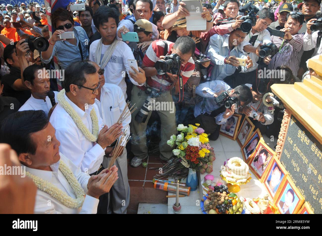(140330) -- PHNOM PENH, 30 marzo 2014 (Xinhua) -- Sam Rainsy (2nd L, fronte), presidente del partito di opposizione Cambodian National Rescue Party (CNRP), prega a Phnom Penh, Cambogia, 30 marzo 2014. Il CNRP domenica mattina ha tenuto una cerimonia religiosa in uno stupa commemorativo in un parco, appena a sud del Palazzo reale, in memoria delle vittime di un attacco di granata 17 anni fa. (Xinhua/li Hong) CAMBOGIA-PHNOM PENH-17TH ANNIVERSARY-GRANADE ATTACK PUBLICATIONxNOTxINxCHN Phnom Penh marzo 30 2014 XINHUA Sat Rainsy 2nd l Front President of the opposition Cambodian National Rescue Party prays in Phnom PE Foto Stock