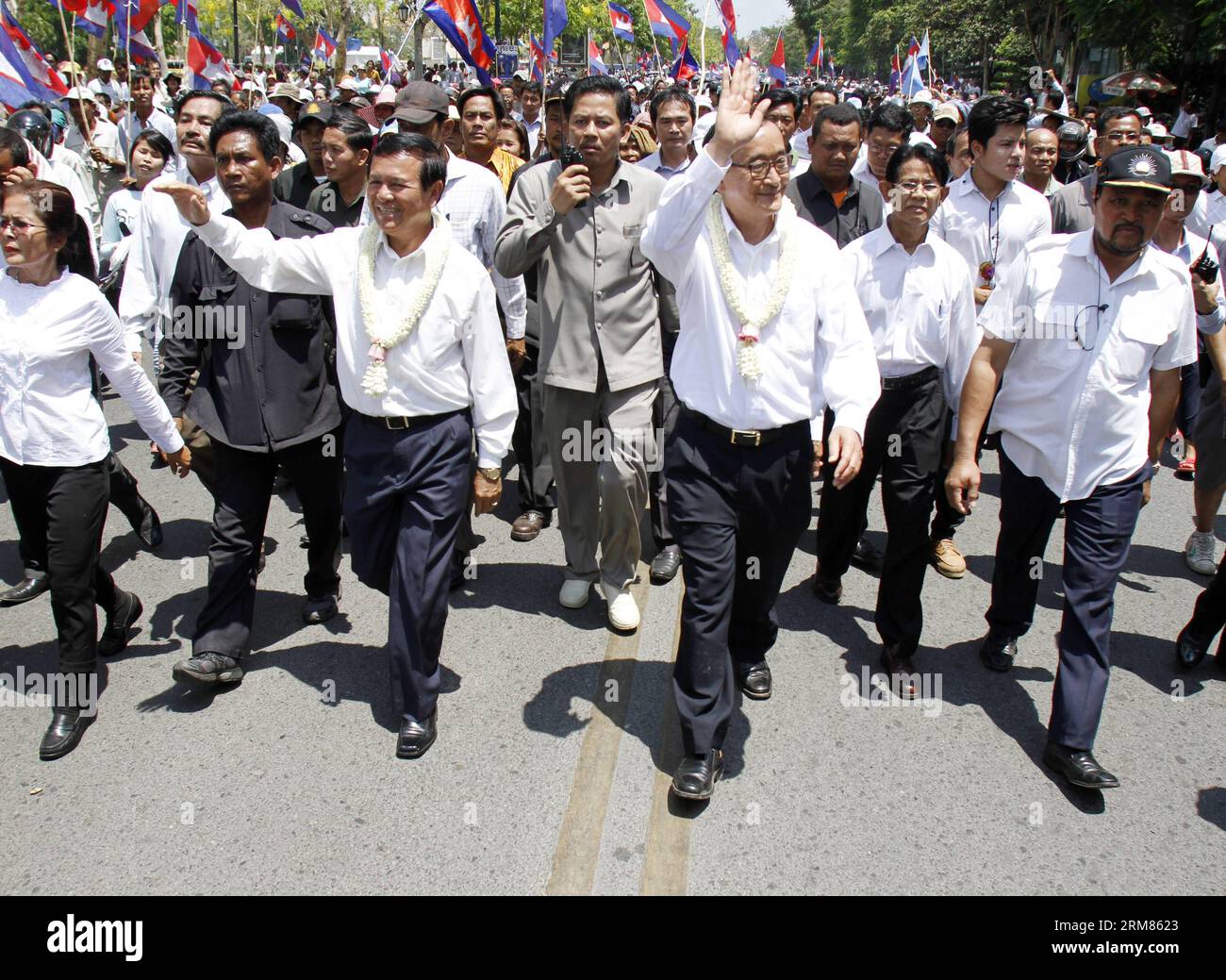 (140330) -- PHNOM PENH, 30 marzo 2014 (Xinhua) -- Sam Rainsy (2° R, fronte), presidente del partito di opposizione Cambodian National Rescue Party (CNRP), saluta i suoi sostenitori a Phnom Penh, Cambogia, 30 marzo 2014. Il CNRP domenica mattina ha tenuto una cerimonia religiosa in uno stupa commemorativo in un parco, appena a sud del Palazzo reale, in memoria delle vittime di un attacco di granata 17 anni fa. (Xinhua/Sovannara) CAMBOGIA-PHNOM PENH-17TH ANNIVERSARY-GRANADE ATTACK PUBLICATIONxNOTxINxCHN Phnom Penh marzo 30 2014 XINHUA Sat Rainsy 2nd r Front President of the opposition Cambodian National Rescue Party Foto Stock