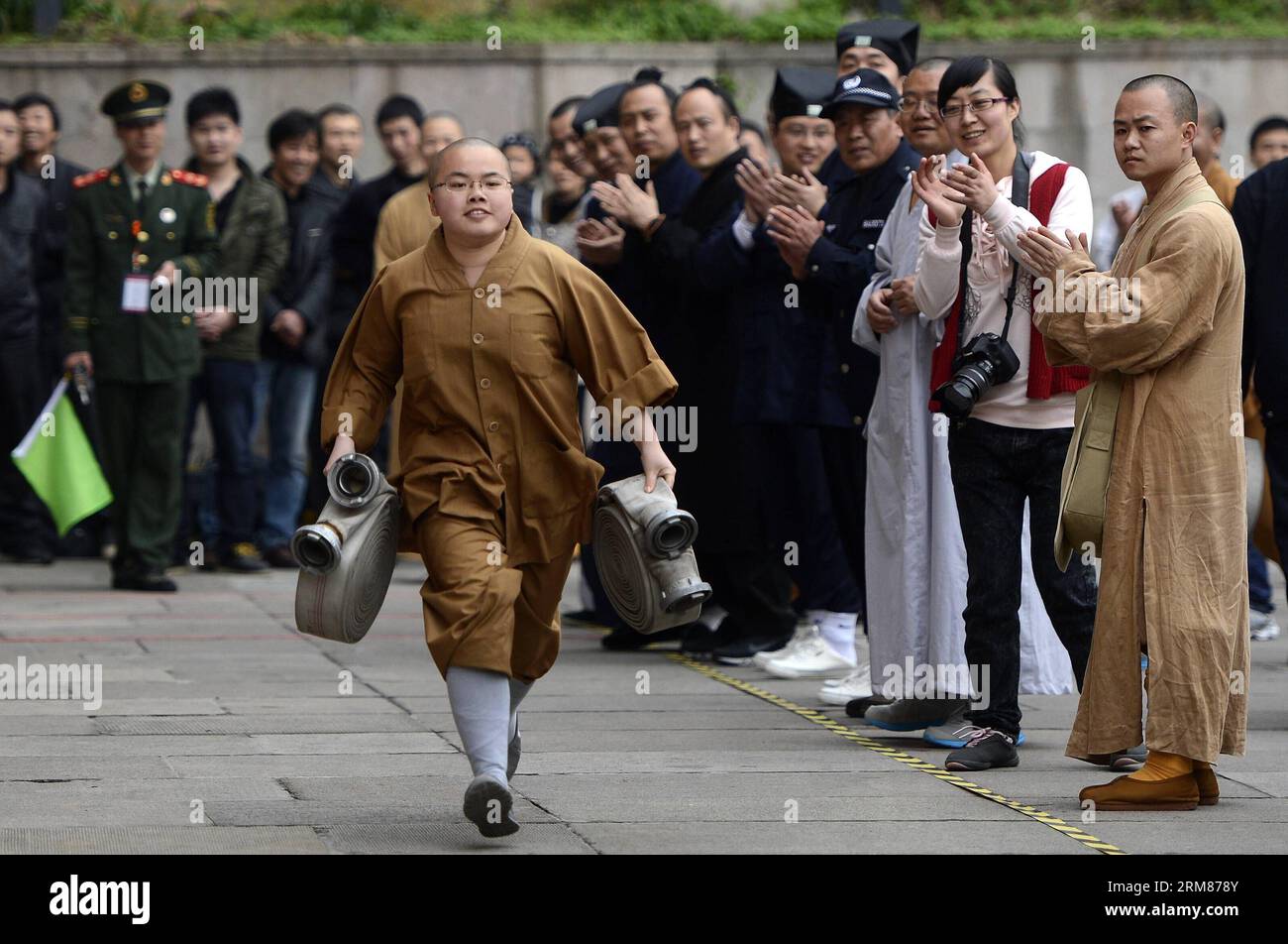Un monaco partecipa a una footrace con peso durante i giochi di fuoco che si tengono a Hangzhou, capitale della provincia di Zhejiang della Cina orientale, il 1 aprile 2014. Martedì si è tenuto qui un gioco del fuoco del circolo religioso di Hangzhou, in cui 60 persone del circolo buddista e taoista hanno gareggiato in eventi antincendio. (Xinhua/Han Chuanhao) (zgp) CHINA-HANGZHOU-FIRE GAMES (CN) PUBLICATIONxNOTxINxCHN a Monk partecipa a Footrace with Weight durante i Fire Games Hero a Hangzhou capitale della provincia dello Zhejiang della Cina orientale 1 aprile 2014 a Fire Games of Hangzhou'S Religious Circle What Hero here ON Tuesday in W. Foto Stock