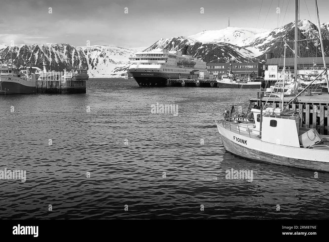 Foto in bianco e nero del traghetto norvegese Hurtigruten, MS NORDNORGE, ormeggiato nel piccolo porto di pesca artico a Honningsvåg, Norvegia Foto Stock