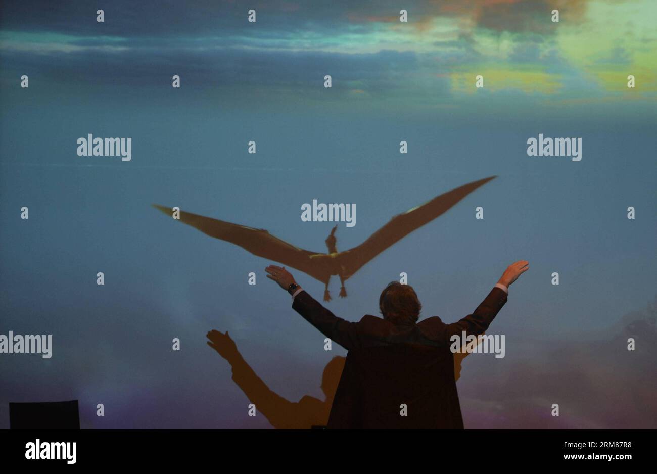 (140401) -- NEW YORK, 1 aprile 2014 (Xinhua) -- Un ricercatore emula la postura volante di uno pterosauro durante l'anteprima della mostra pterosaurs: Flight in the Age of the Dinosaurs presso l'American Museum of Natural History di New York, 1 aprile 2014. La mostra speciale inizierà il 5 aprile, con fossili rari, modelli a grandezza naturale e interazioni interattive. (Xinhua/Wang lei) US-NEW YORK-EXHIBITION-DINOSAURI PUBLICATIONxNOTxINxCHN New York 1 aprile 2014 XINHUA un ricercatore la postura volante di a durante l'Anteprima della mostra pterosauri volo nell'età dei dinosauri Foto Stock