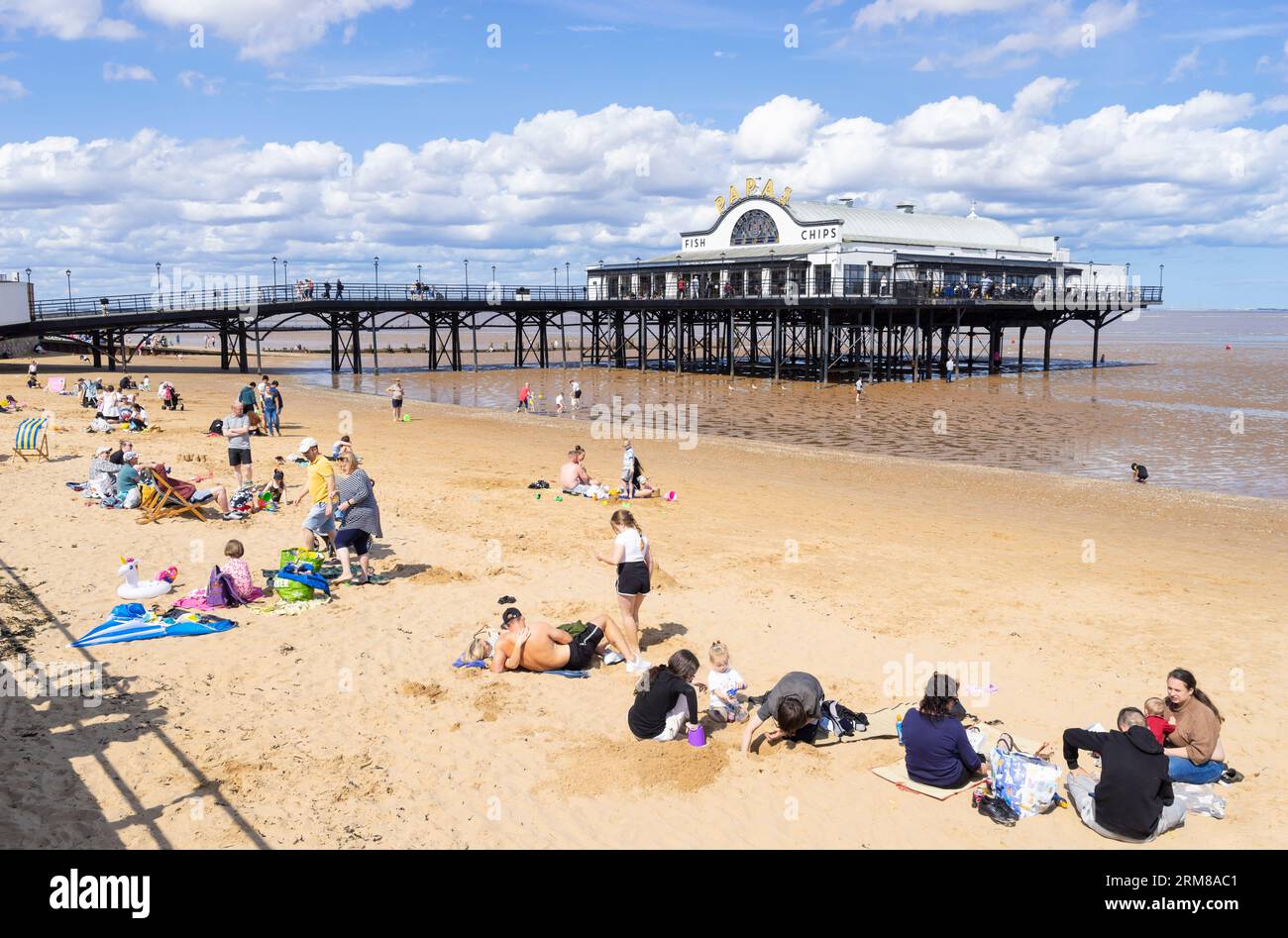 Spiaggia di Cleethorpes con turisti e molo di Pier Cleethorpes con ristorante Papas fish and chips a Cleethorpes Lincolnshire Inghilterra Regno Unito GB Europa Foto Stock