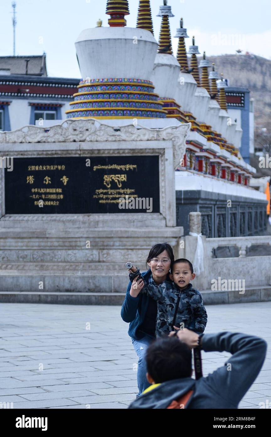 (140406) -- CONTEA DI HUANGZHONG, 6 aprile 2014 (Xinhua) -- due turisti si pongono per delle foto nel monastero di Kumbum nella contea di Huangzhong di Xining, capitale della provincia del Qinghai della Cina nord-occidentale, 6 aprile 2014. Il monastero di Kumbum è una destinazione principale per i pellegrini buddisti tibetani. E' anche una grande attrazione turistica nel Qinghai, che presenta splendidi murales religiosi, appliques Thangka e sculture di burro. (Xinhua/Wu Gang) (lmm) CINA-QINGHAI-KUMBUM MONASTERY-TOURISM (CN) PUBLICATIONxNOTxINxCHN Huang Zhong County 6 aprile 2014 XINHUA due turisti si pongono per delle foto nel monastero di Kumbum a Hu Foto Stock