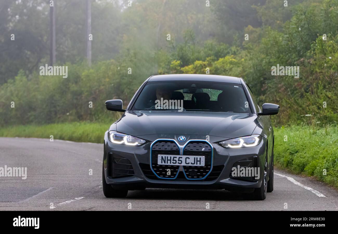 Whittlebury, Northants, Regno Unito - 26 agosto 2023: 2022 BMW 14 edrive 40 M auto elettrica sportiva che viaggia su una strada di campagna inglese in una mattinata umida e nebbiosa. Foto Stock