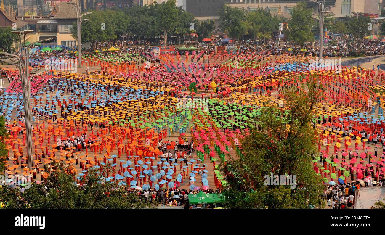 Le persone del gruppo etnico dai eseguono la danza ombrello nella città di Jinghong, prefettura autonoma dai di Xishuangbanna, provincia dello Yunnan della Cina sud-occidentale, 14 aprile 2014. Un totale di 10.580 persone hanno preso parte alla danza, stabilendo un record mondiale per la più grande scala di danza ombrello del gruppo etnico dai. (Xinhua/Lin Yiguang) (mp) CHINA-YUNNAN-XISHUANGBANNA-DAI ETHNIC Group-UMBREALLA DANCE (CN) PUBLICATIONxNOTxINxCHN Celebrities from dai Ethnic Group eseguono Umbrella Dance nella città di Jinghong Prefettura autonoma di Xishuangbanna nella provincia dello Yunnan della Cina sud-occidentale 14 aprile 2014 per un totale di 10 580 C. Foto Stock